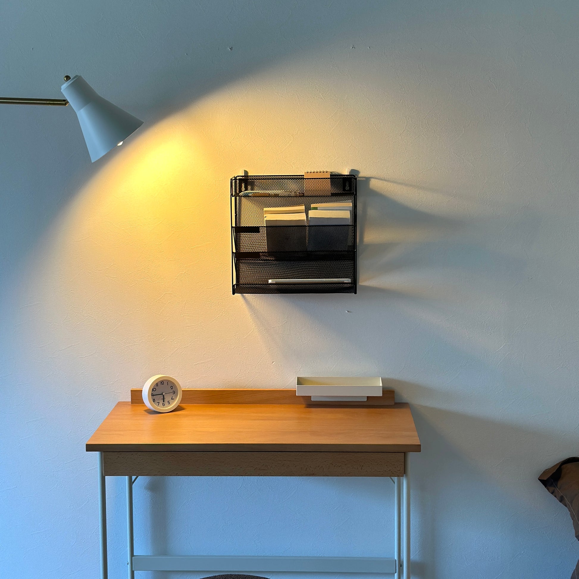 ブラックのメッシュデザインの4段構造ラックを壁にかけている様子