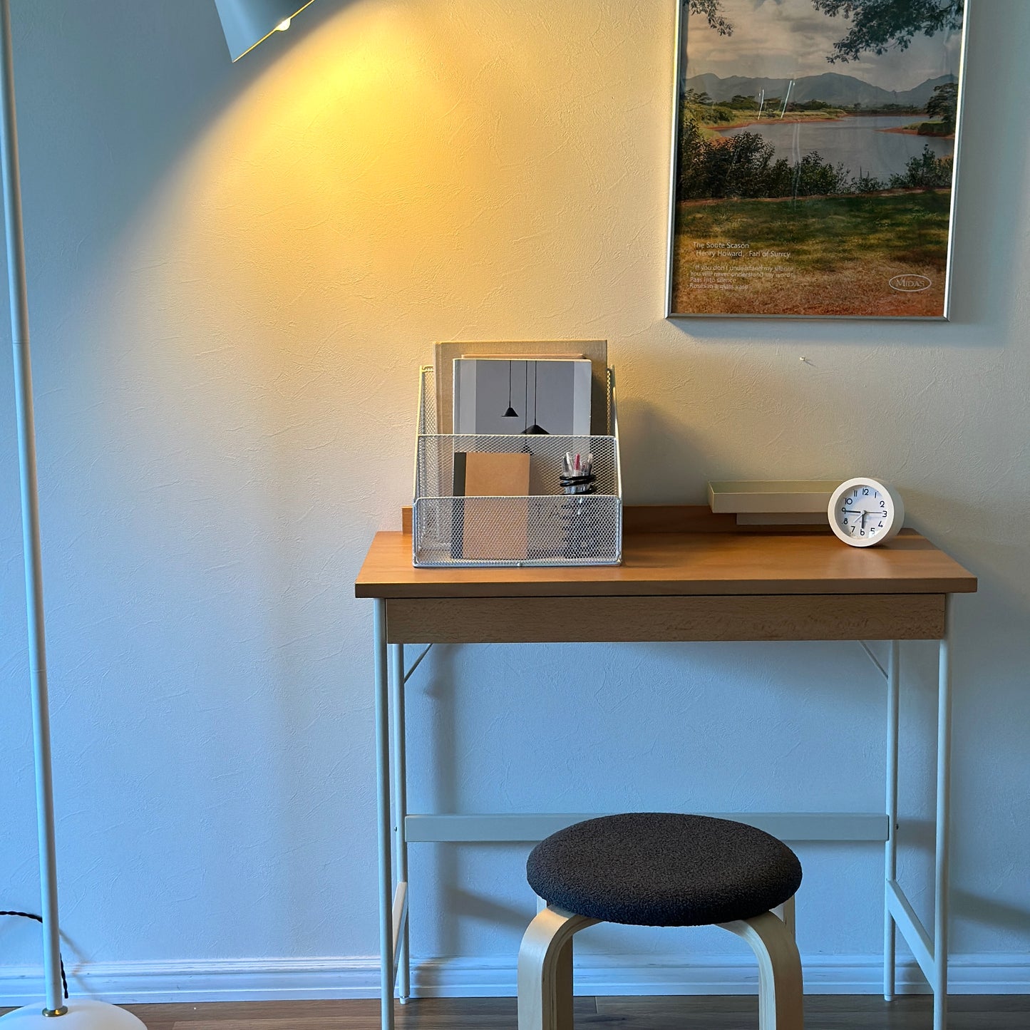 ホワイトのアイアン素材のメッシュ収納ラックに雑誌やペンを入れている様子