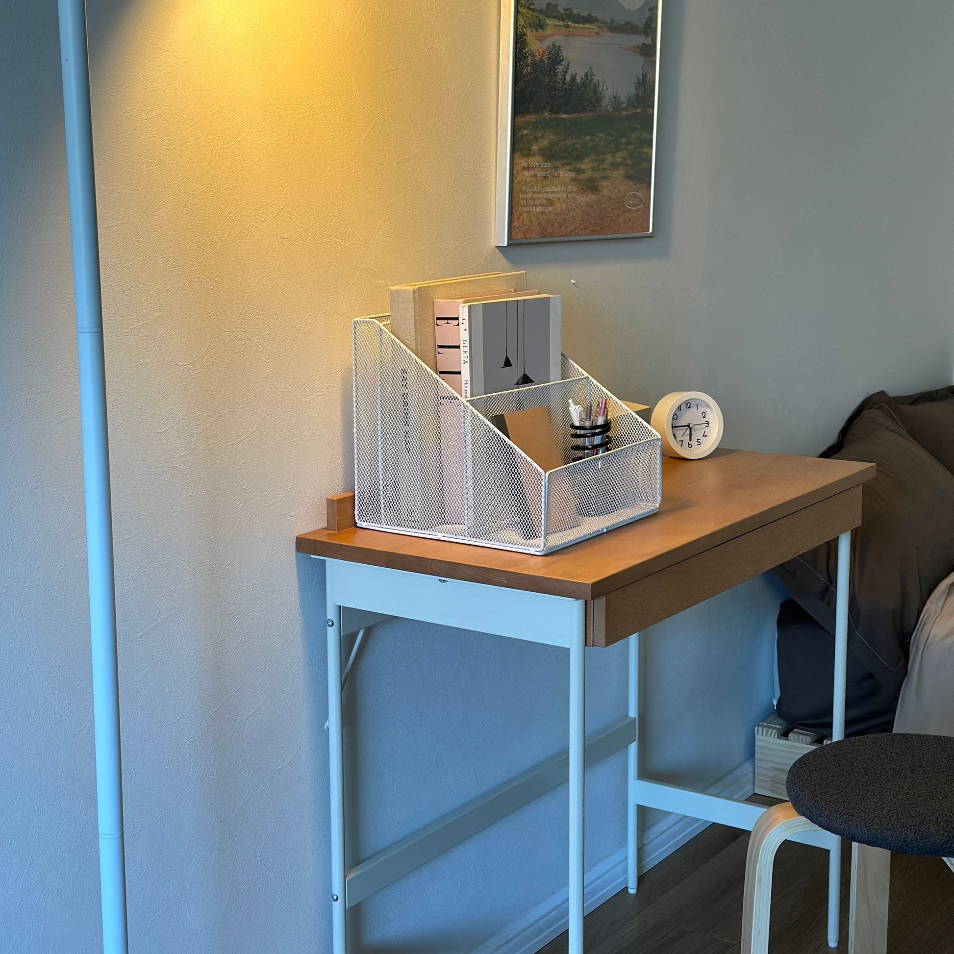 ホワイトのアイアン素材のメッシュ収納ラックをデスクに置いている様子