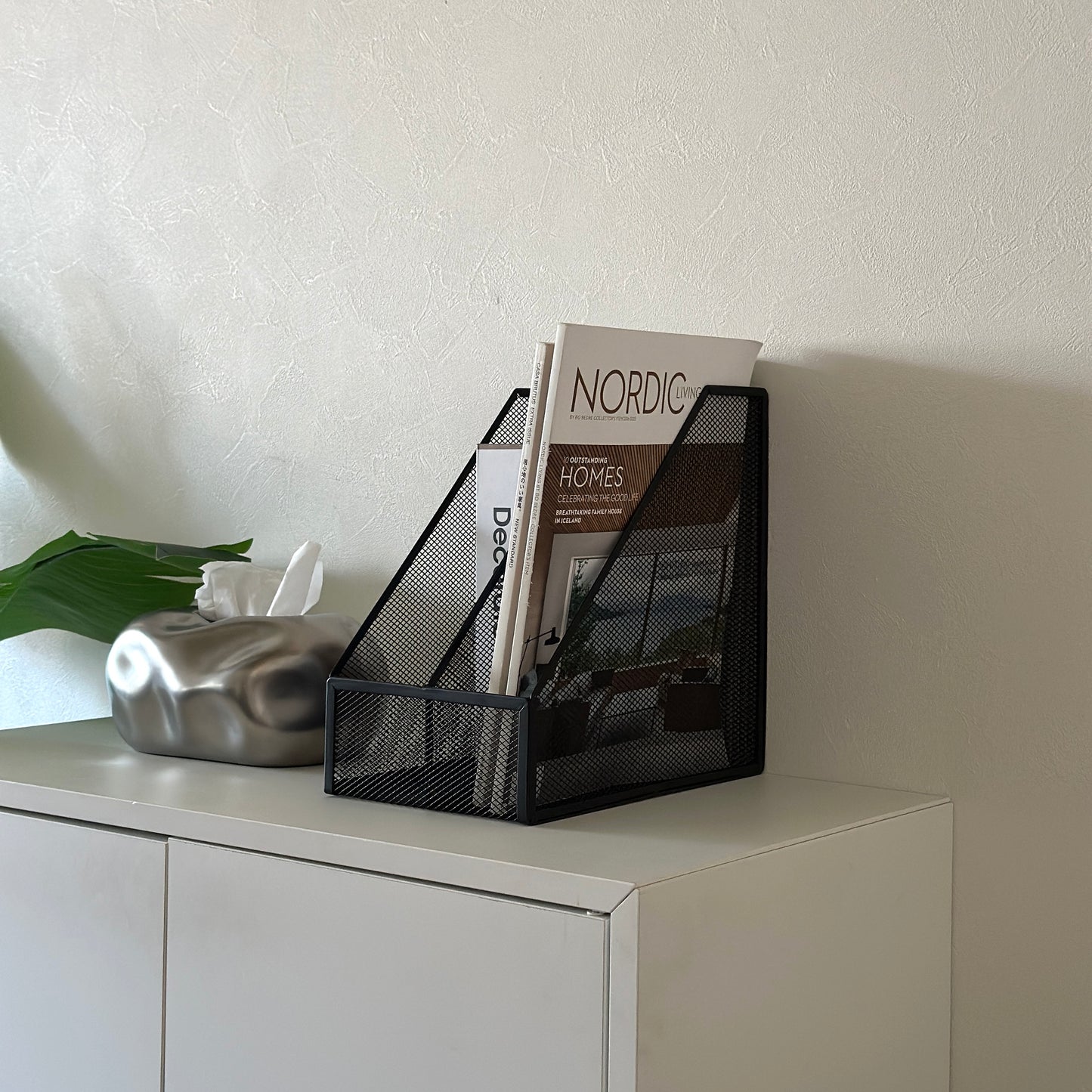 ブラックの卓上ブック収納ラックに雑誌を入れている様子
