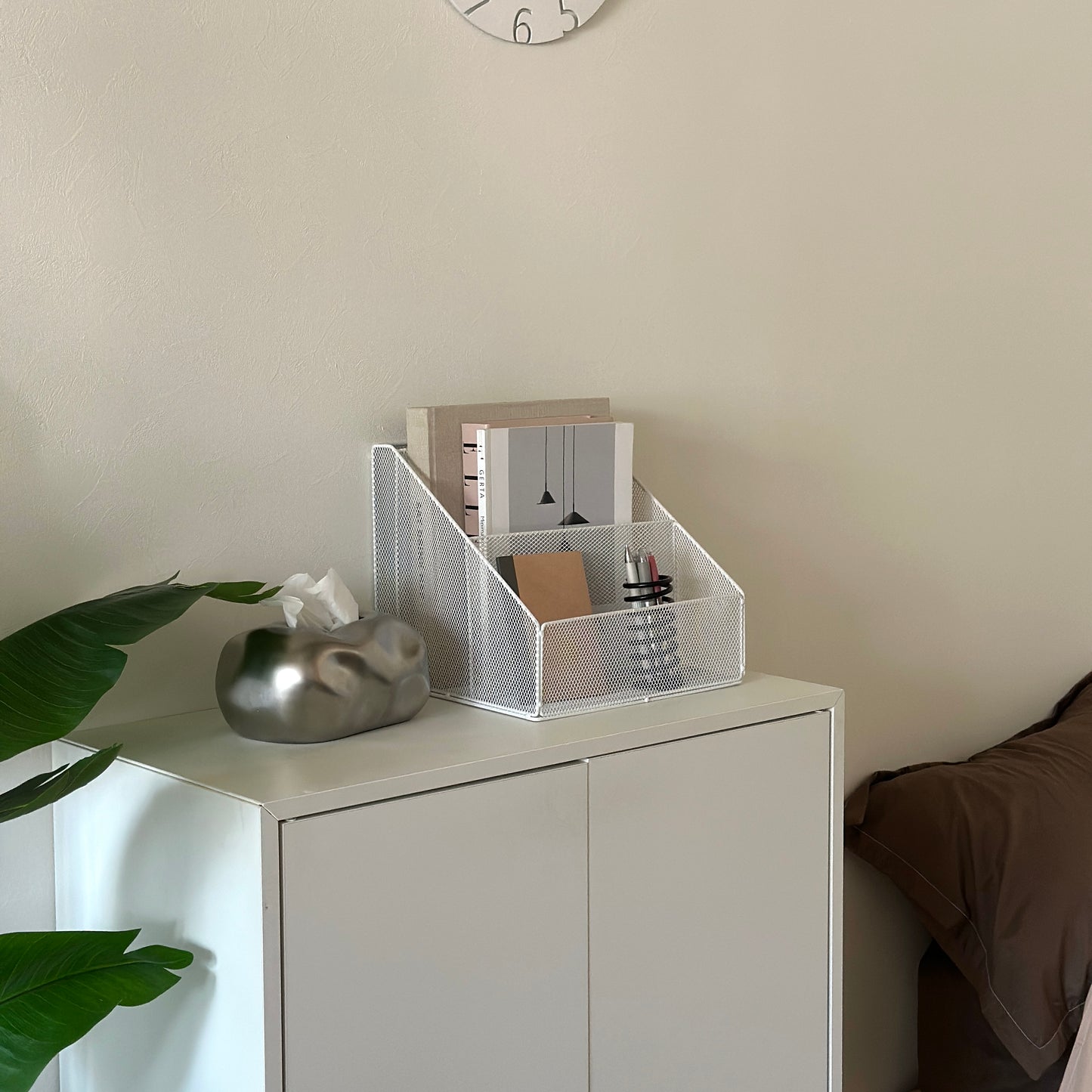 ホワイトのアイアン素材のメッシュ収納ラックを白棚の上に置いている様子