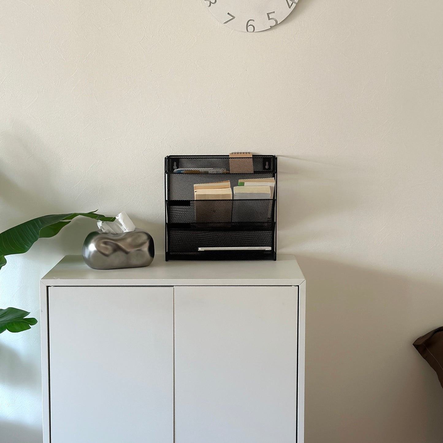 ブラックのメッシュデザインの4段構造ラックが白棚の上に置かれてある様子