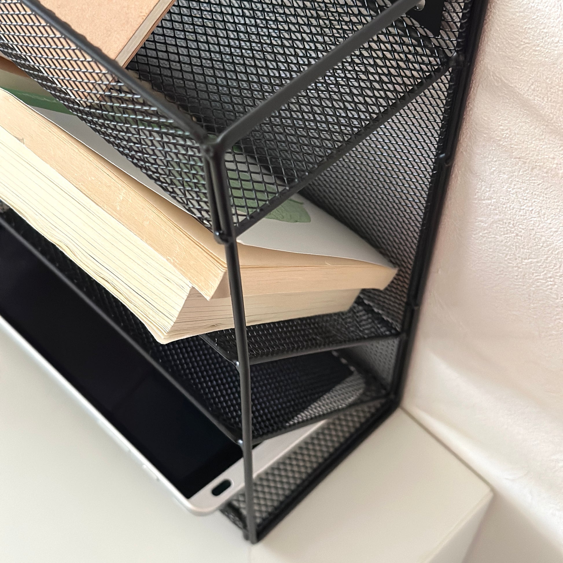 ブラックのメッシュデザインの4段構造ラックに文庫本やiPadが入れられている様子