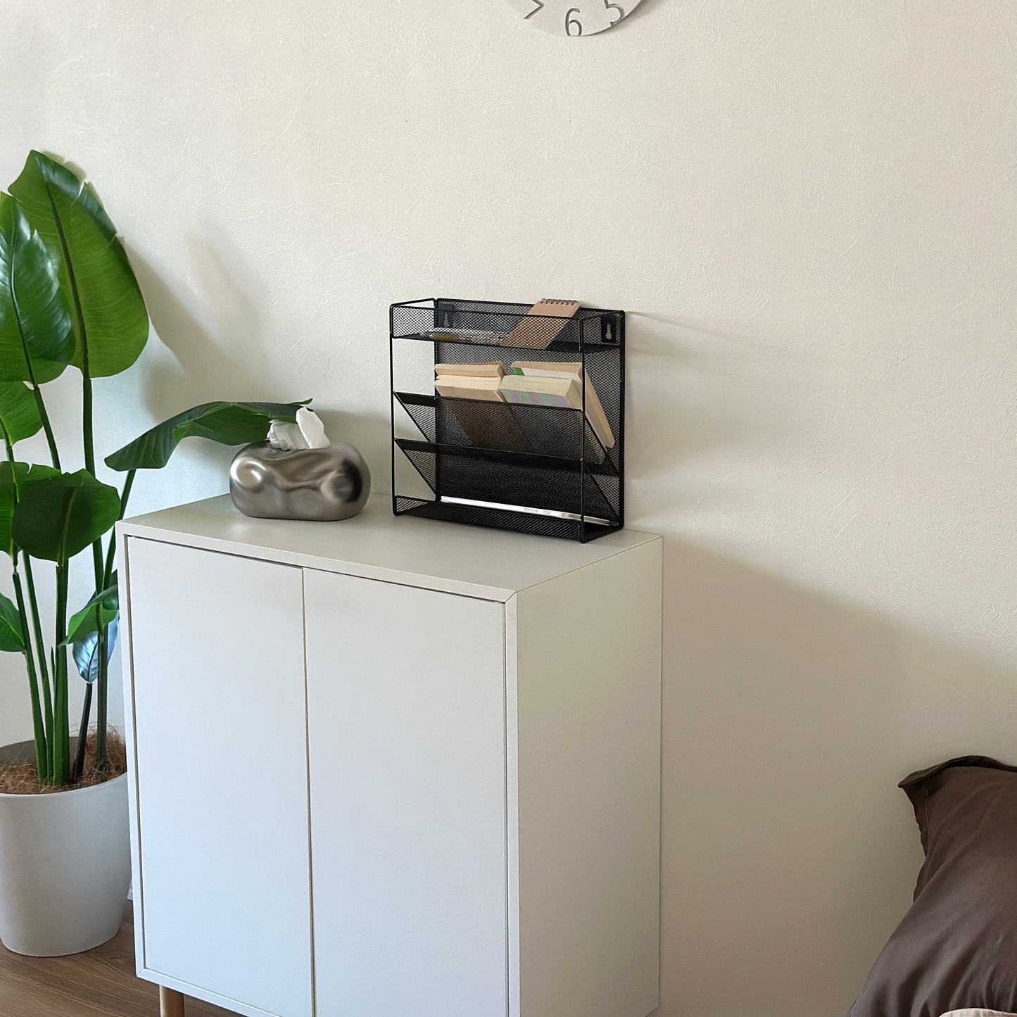 ブラックのメッシュデザインの4段構造ラックを白棚の上に置いている様子