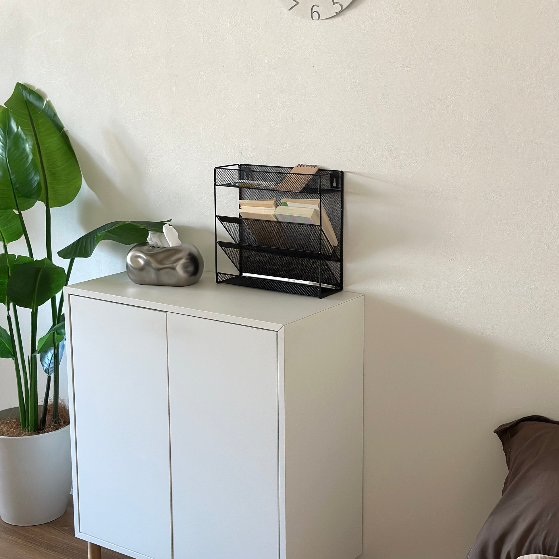 ブラックのメッシュデザインの4段構造ラックを白棚の上に置いている様子