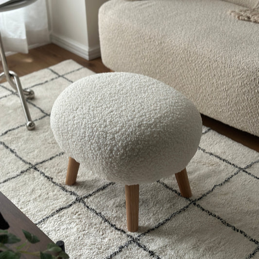 白のブークレ生地とナチュラルな木脚の丸いフォルムのスツール