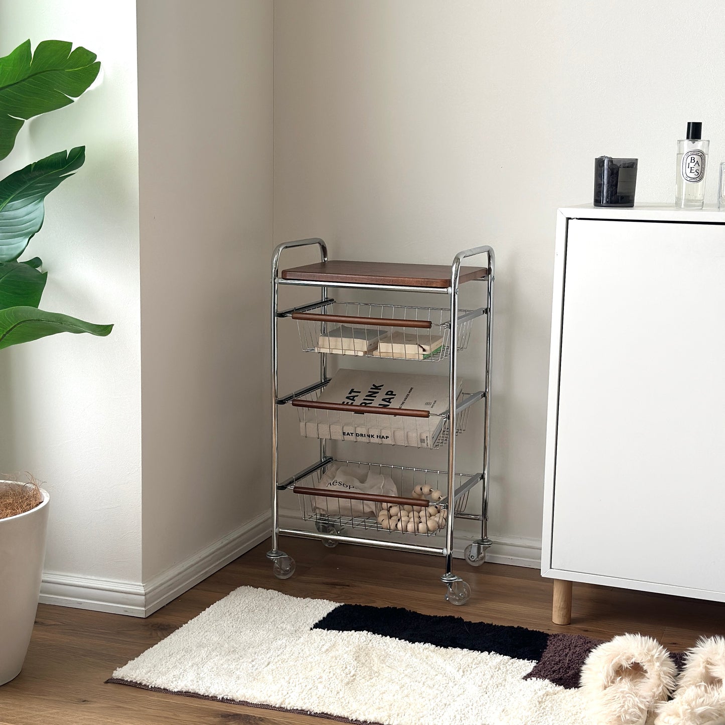 ステンレスとウッド天板の収納ワゴンをホワイトのシェルフ横に置いている様子