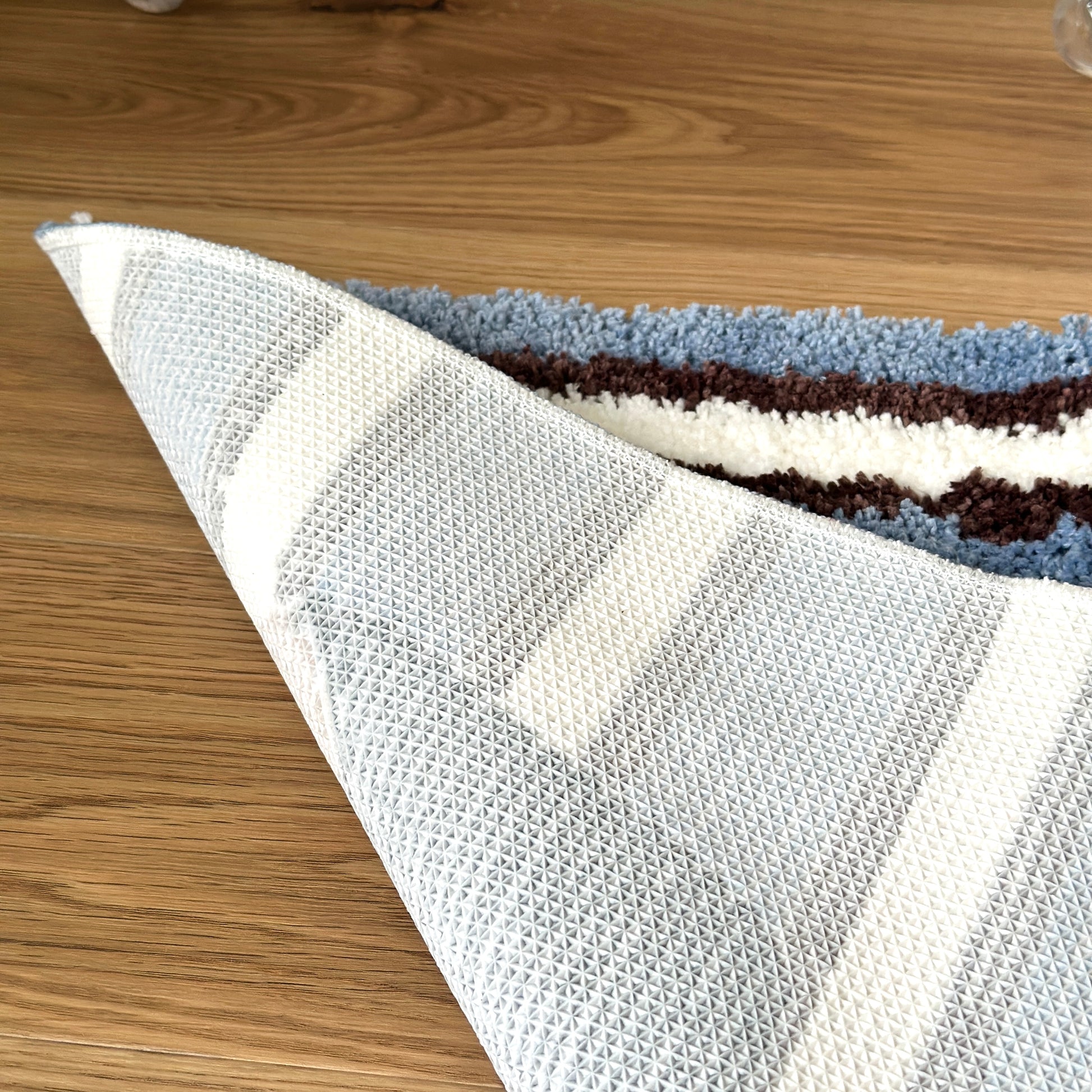 コーヒーカップがモチーフのミニラグの裏側をめくった様子