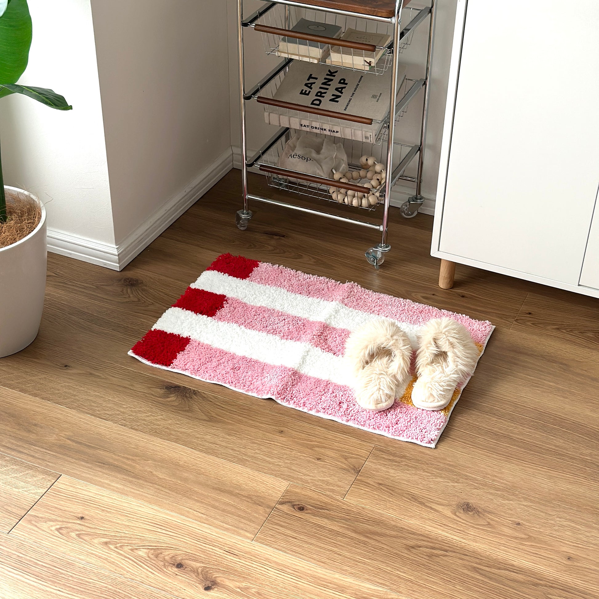 ピンクのブロックカラーが特徴的なミニラグを部屋に敷いている様子