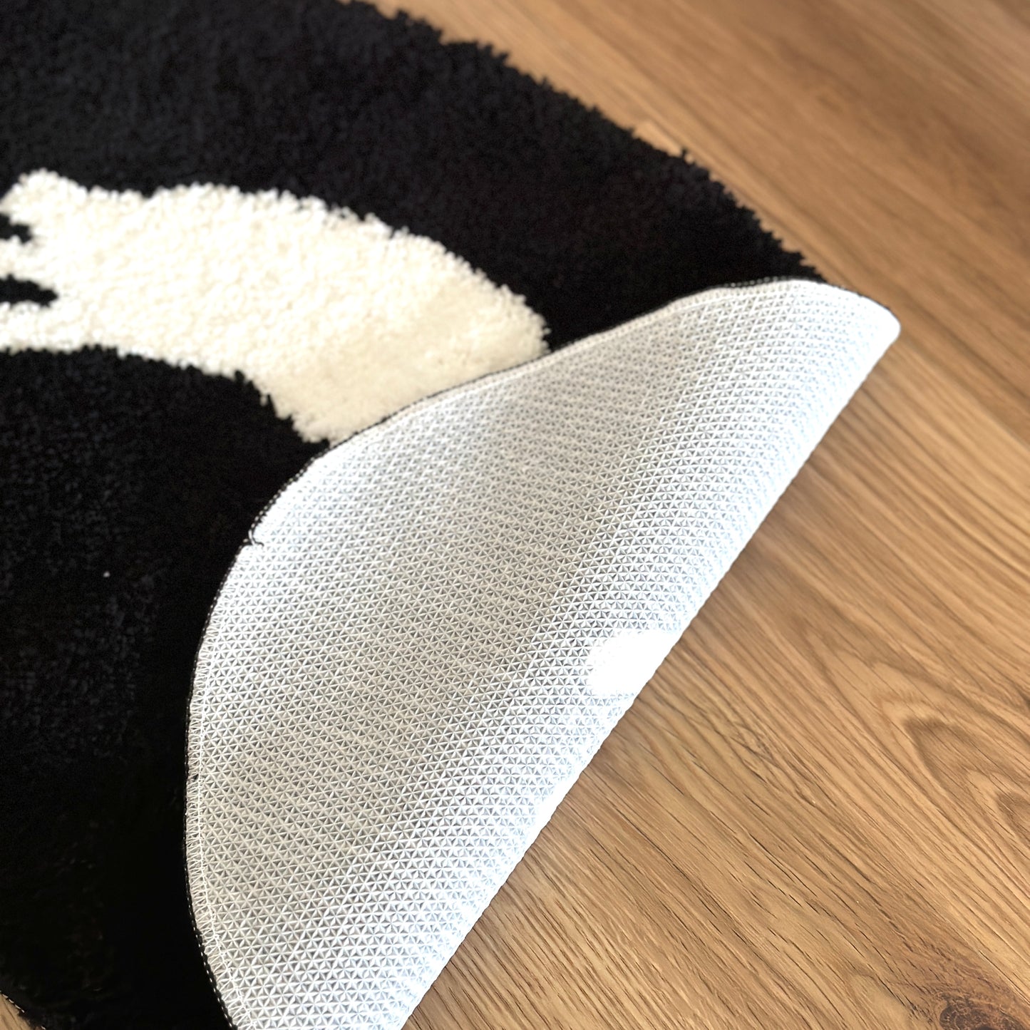 眠る犬がイラストされたミニラグの裏側をめくった様子