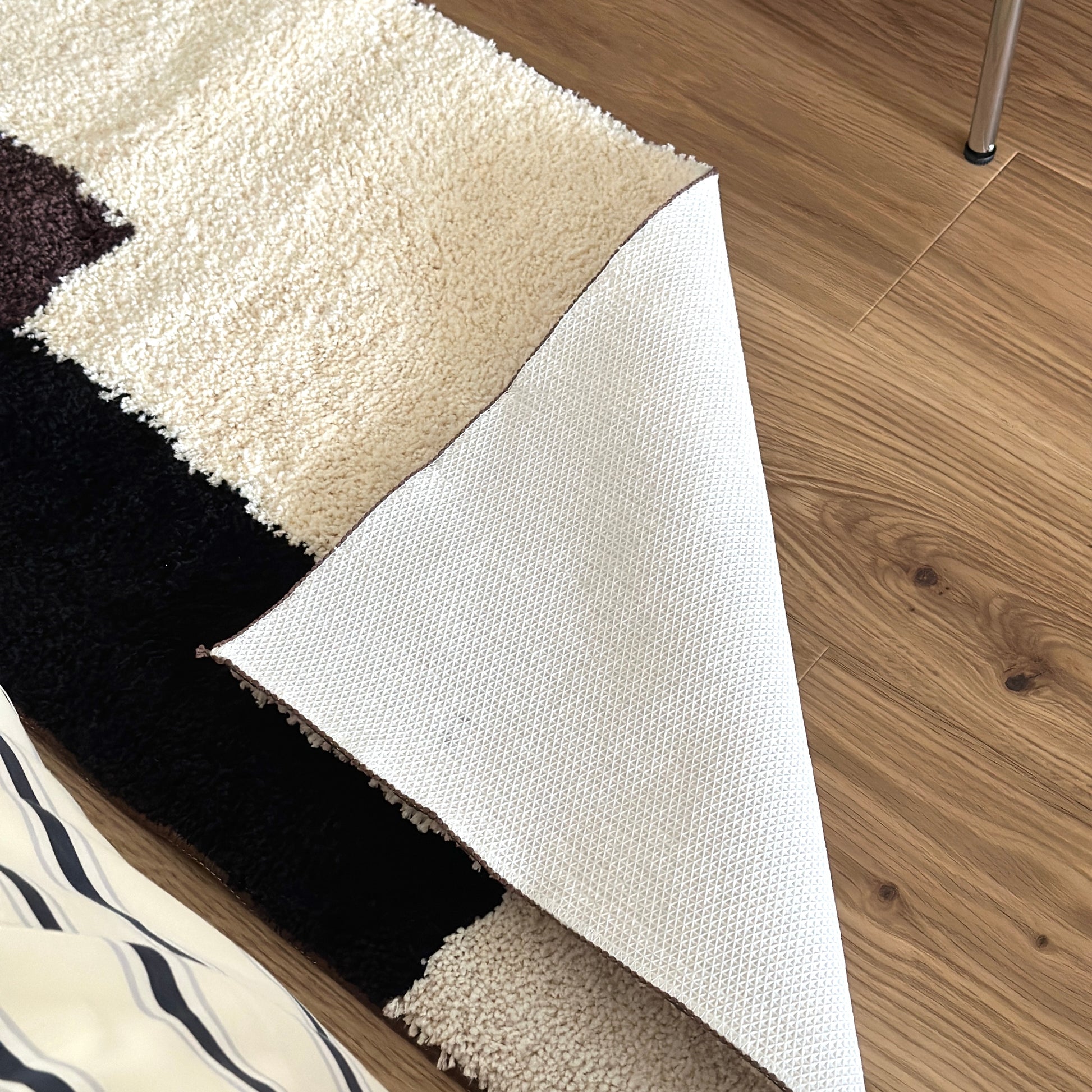 シンプルなブロックカラーのロングラグの裏側をめくった様子