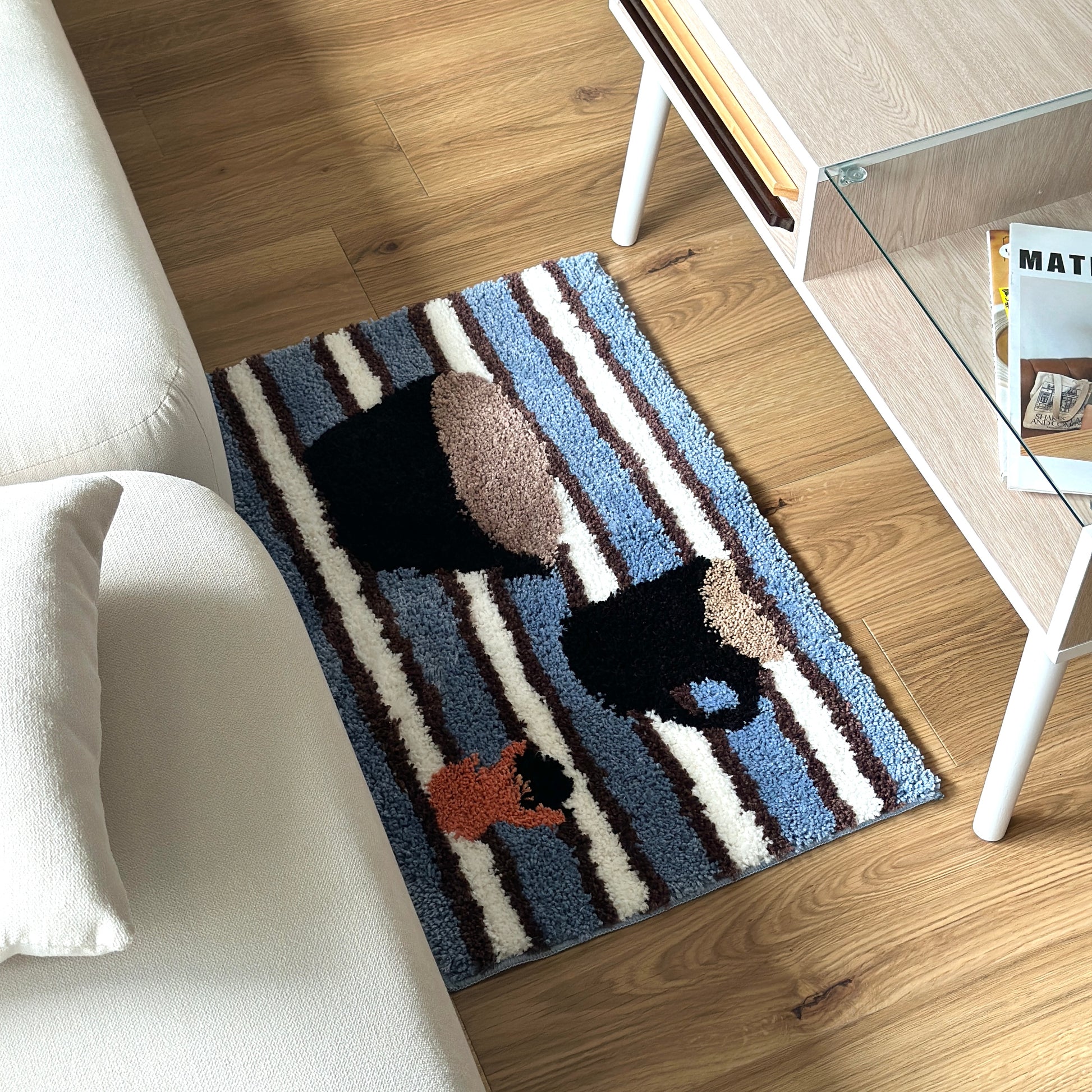 コーヒーカップがモチーフのミニラグをソファとローテーブルの間に敷いている様子