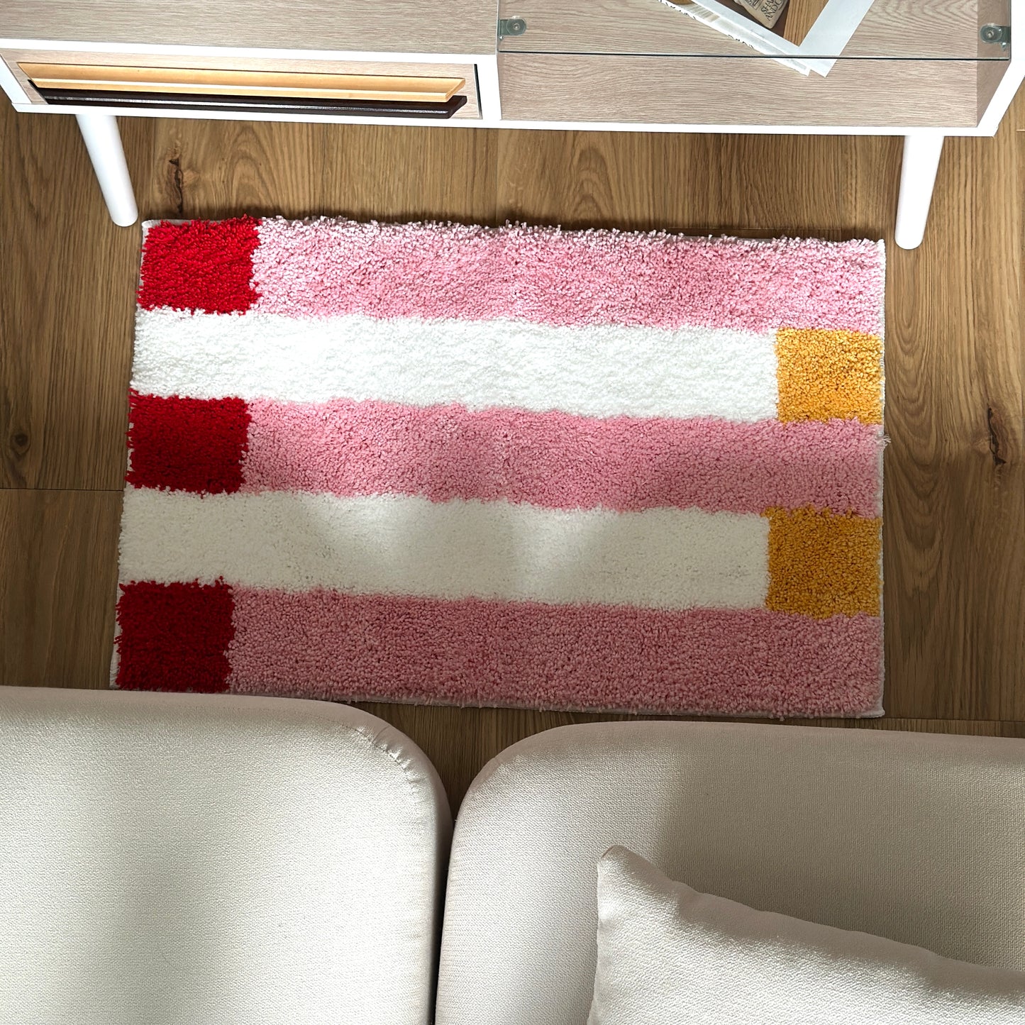ピンクのブロックカラーが特徴的なミニラグを部屋に敷いている様子