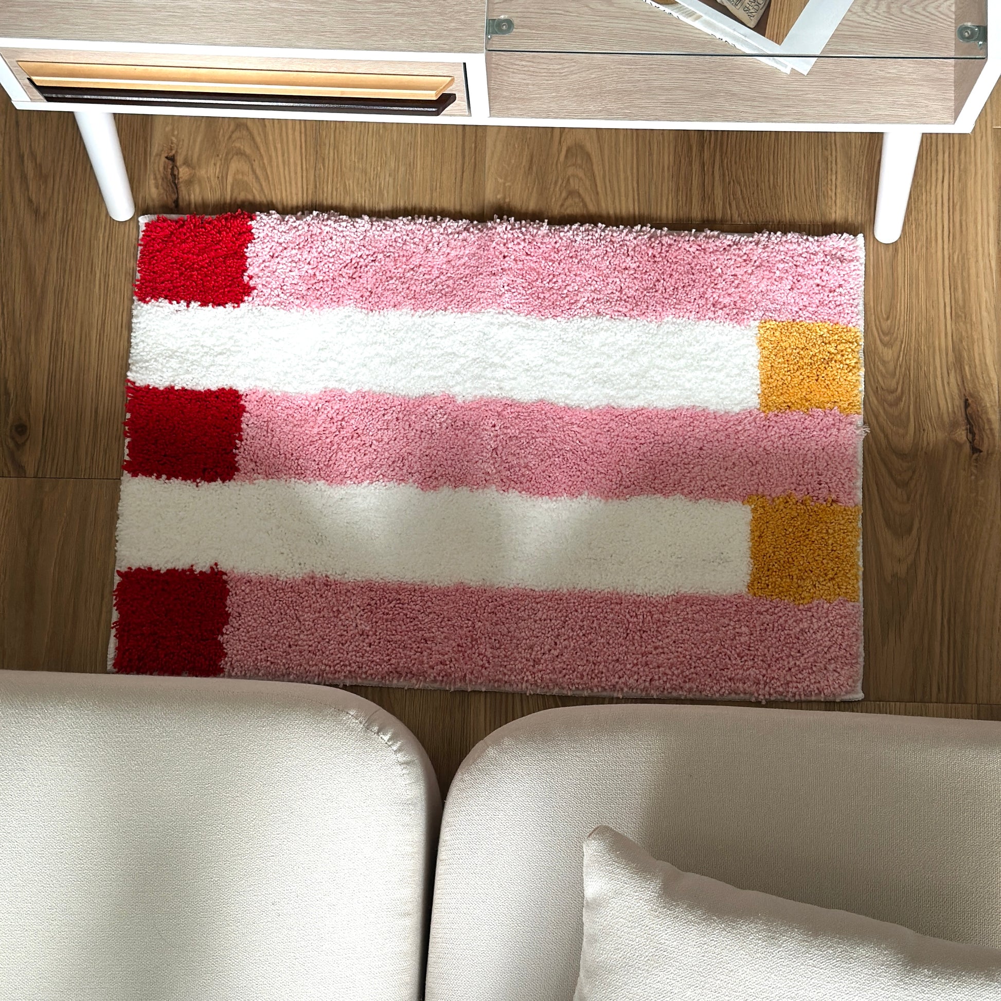 ピンクのブロックカラーが特徴的なミニラグを部屋に敷いている様子