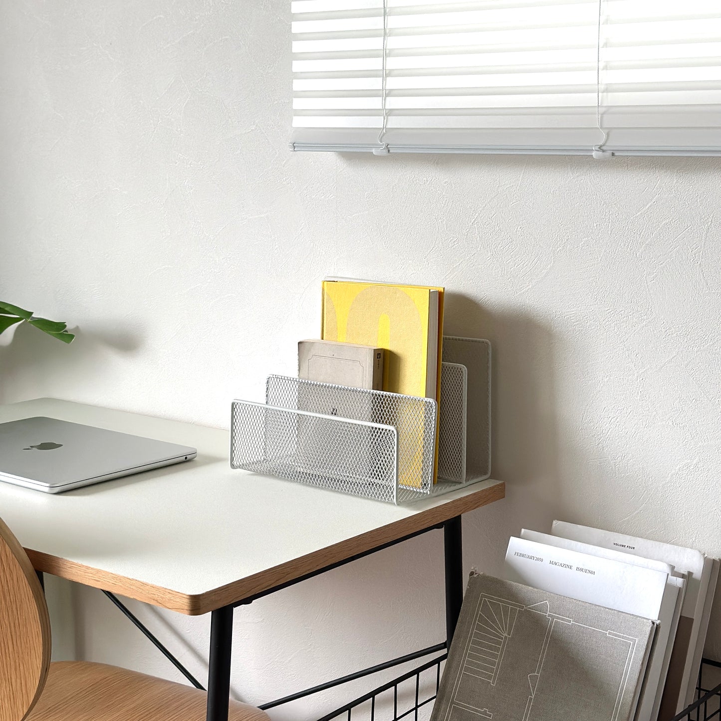 ホワイトのアイアン素材のマガジンラックをデスクに置いている様子