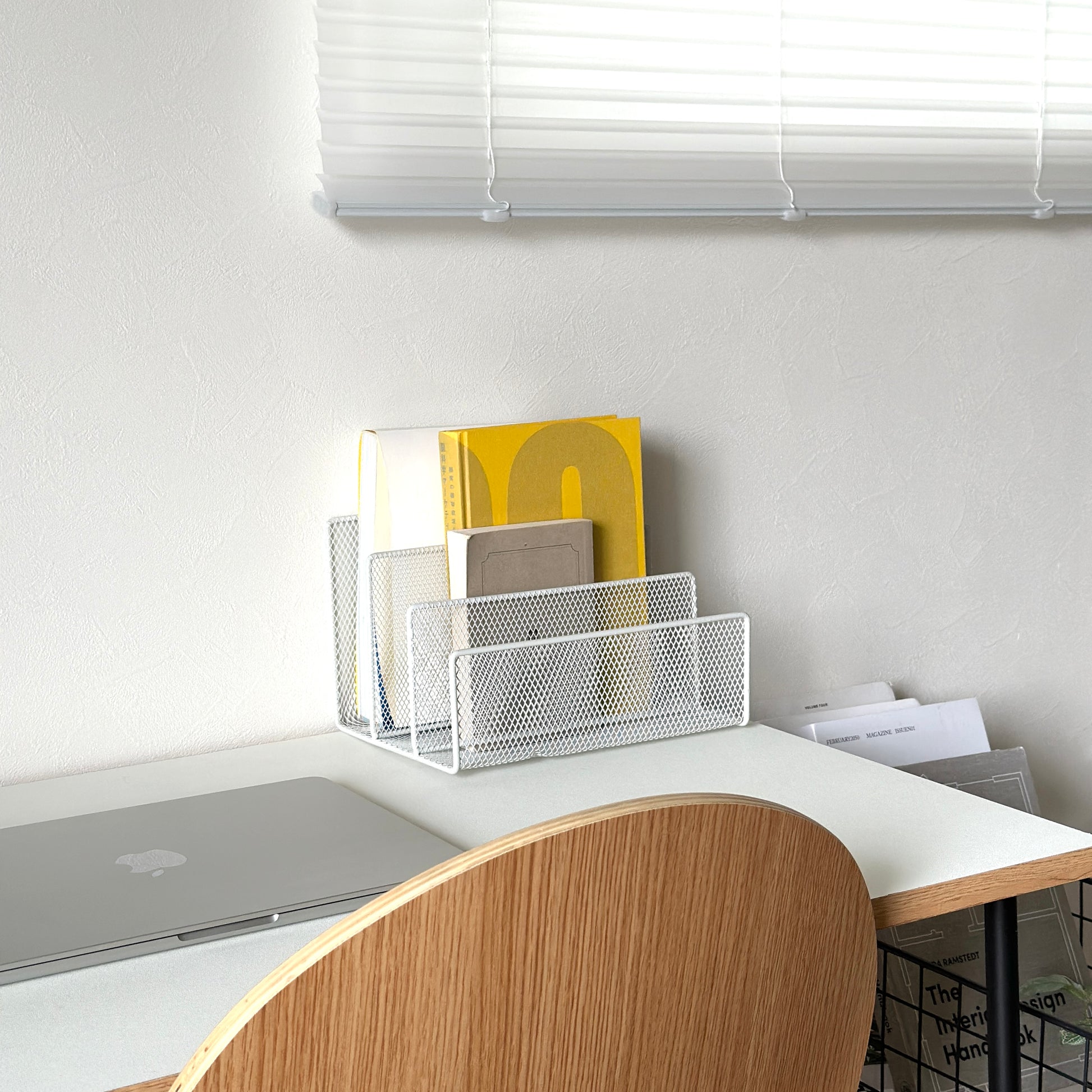 ホワイトのアイアン素材のマガジンラックをデスク上に置いている様子