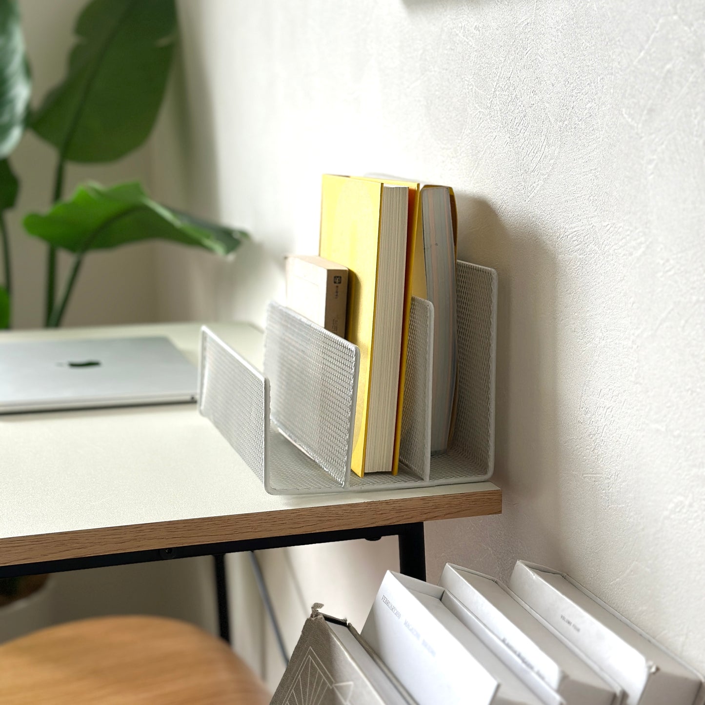 ホワイトのアイアン素材のマガジンラックをデスクに置いている様子