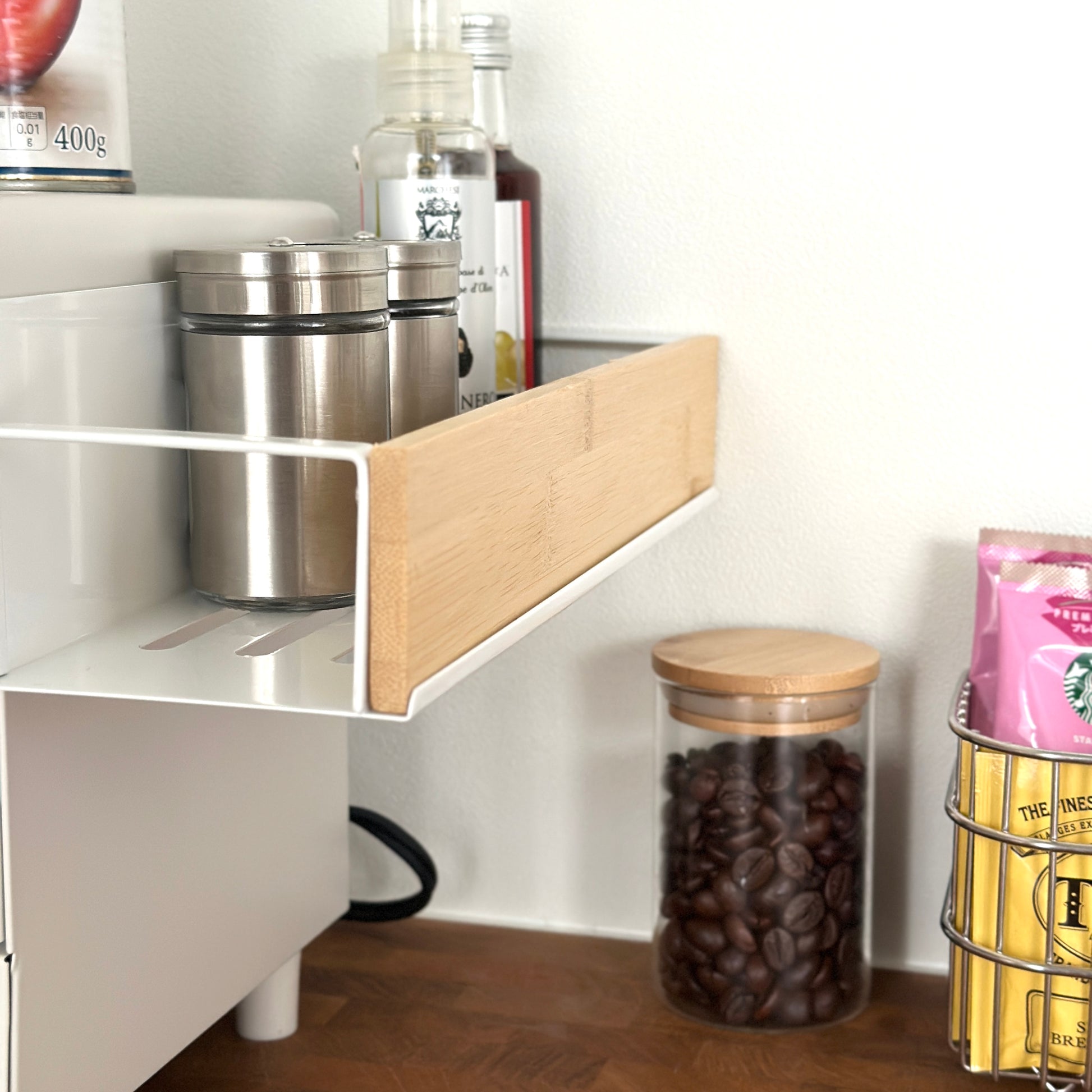 キッチン調味料ラックをオーブンの側面に貼り付けしている状態をアップで写している様子