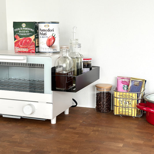 シンプル調味料ラックをオーブンの側面に貼り付けしている様子