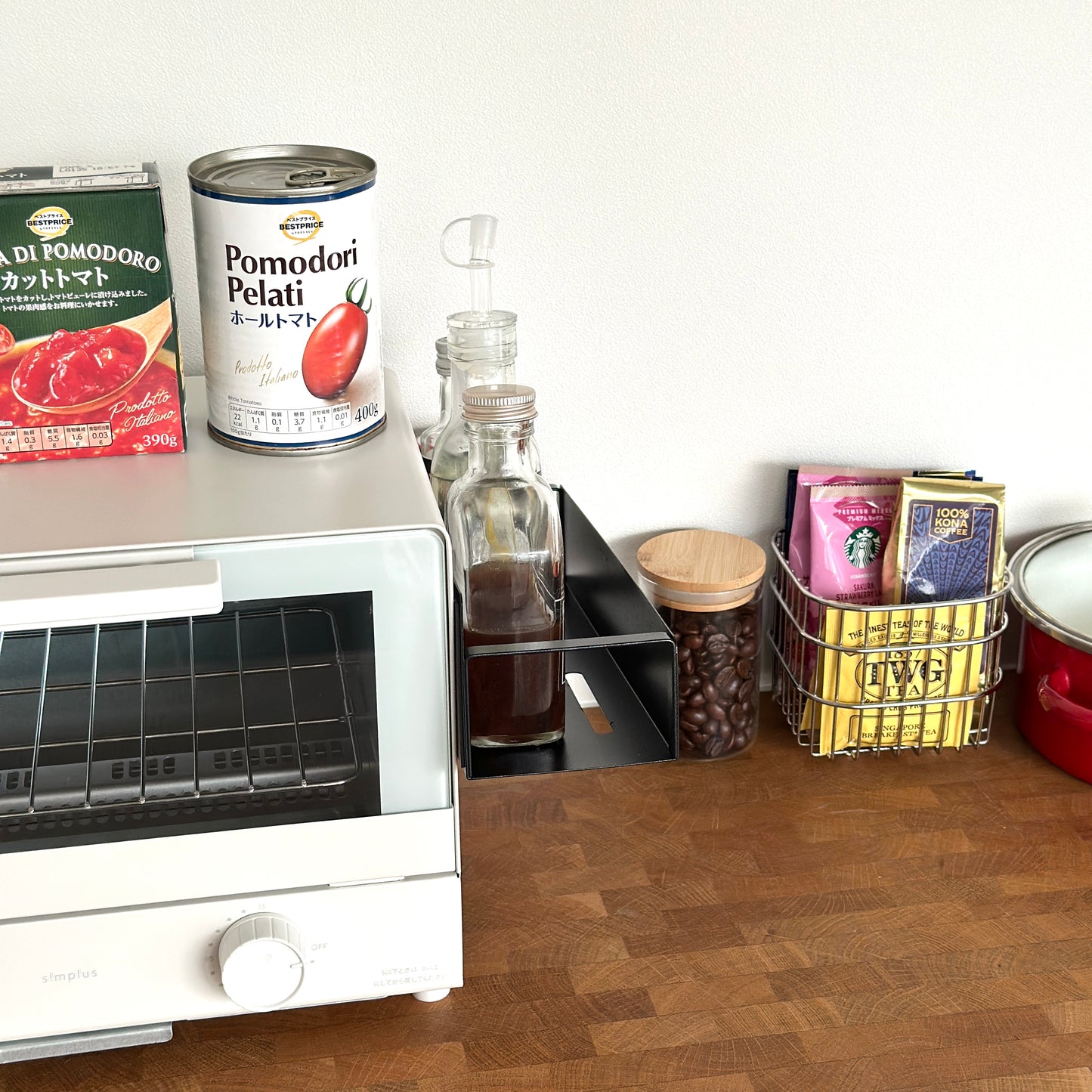 シンプル調味料ラックをオーブンの側面に貼り付けしている様子