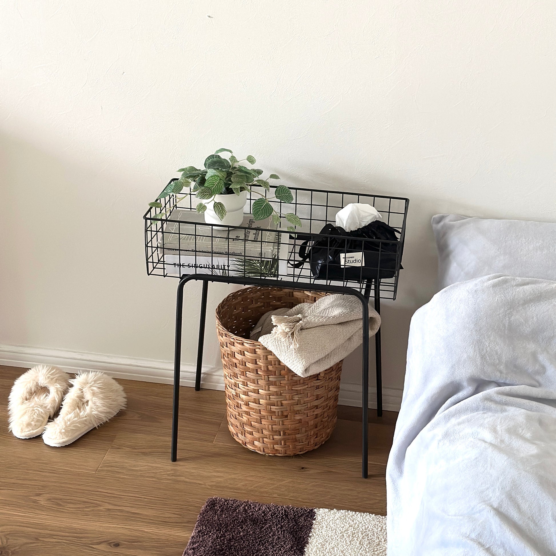 ブラックのアイアン素材とワイヤーメッシュデザインの収納ワゴンにティッシュケースと植物、本を入れている様子