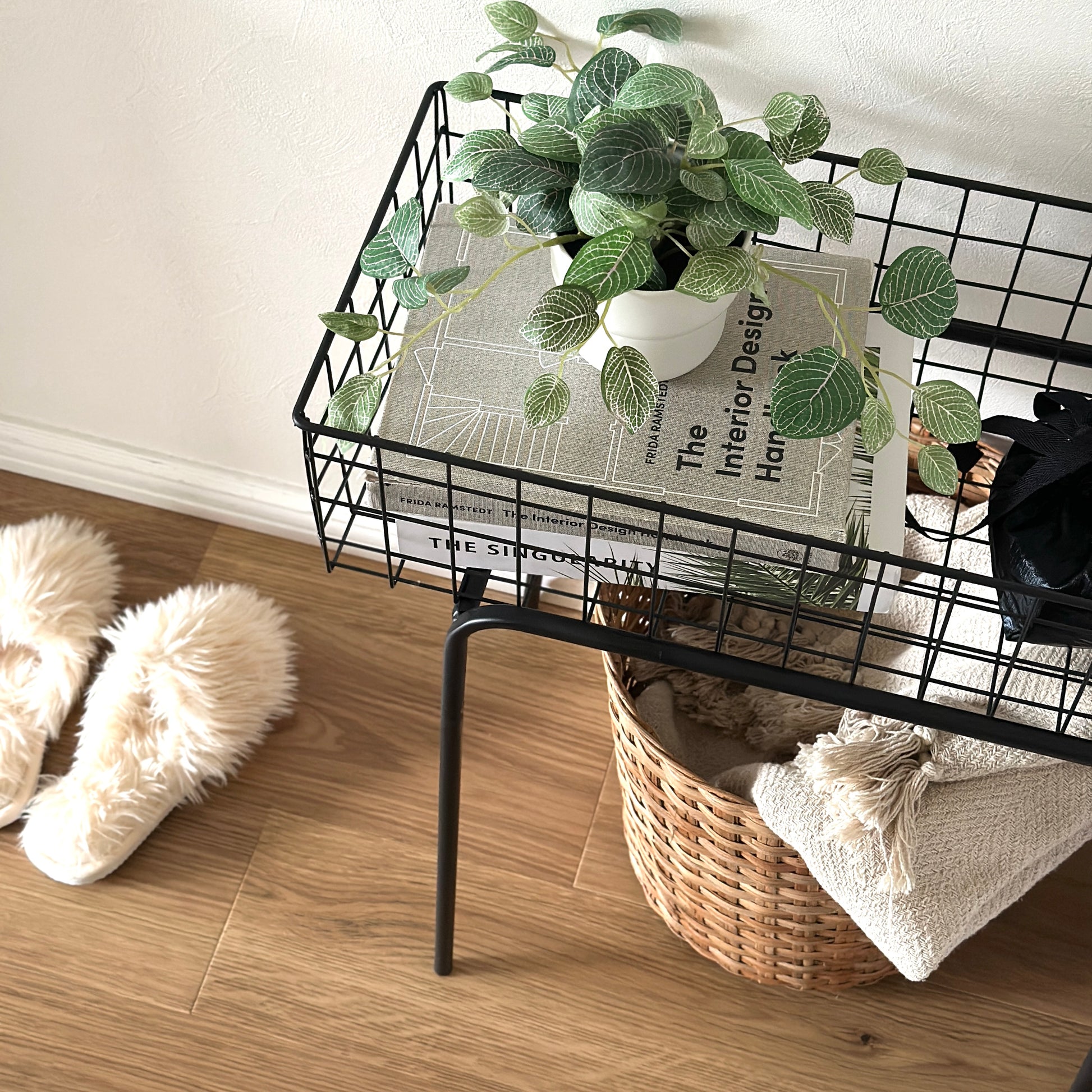 ブラックのアイアン素材とワイヤーメッシュデザインの収納ワゴンに植物と雑誌が置かれてある様子