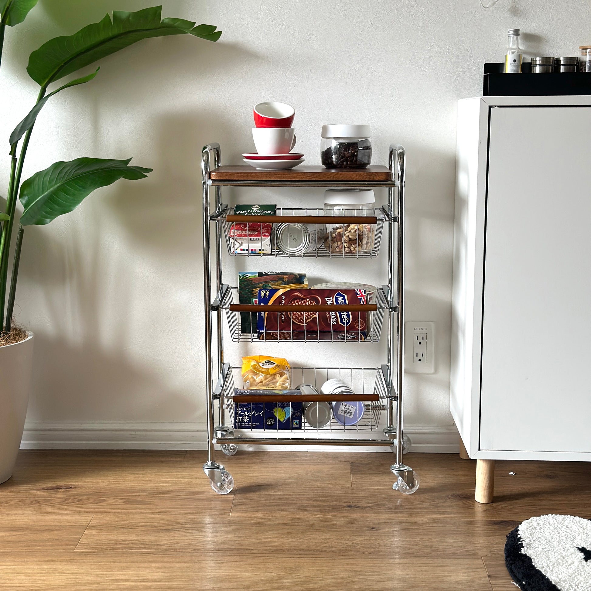 ステンレスとウッド天板の収納ワゴンに食料品を収納している様子