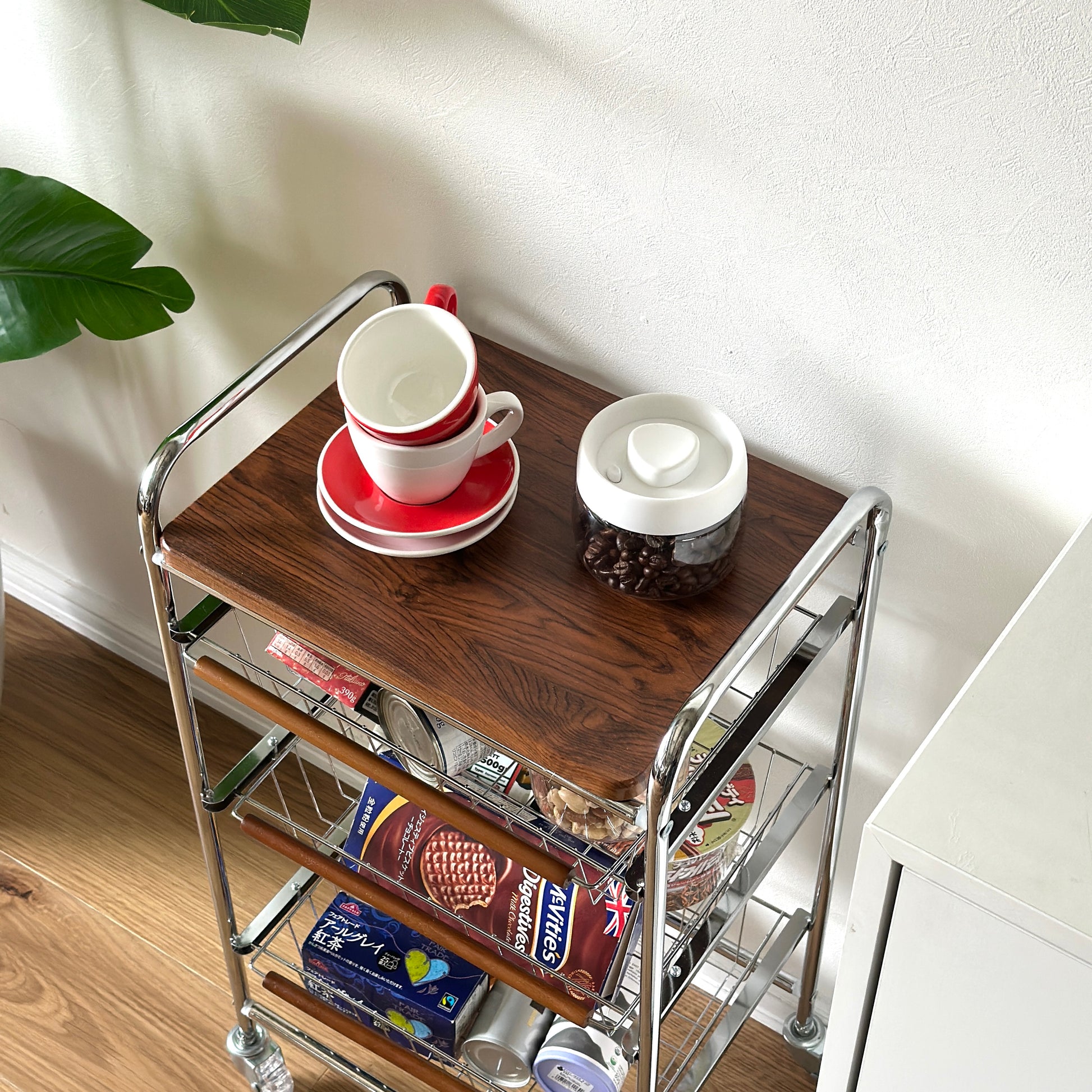 ステンレスとウッド天板の収納ワゴンに食料品を収納している様子