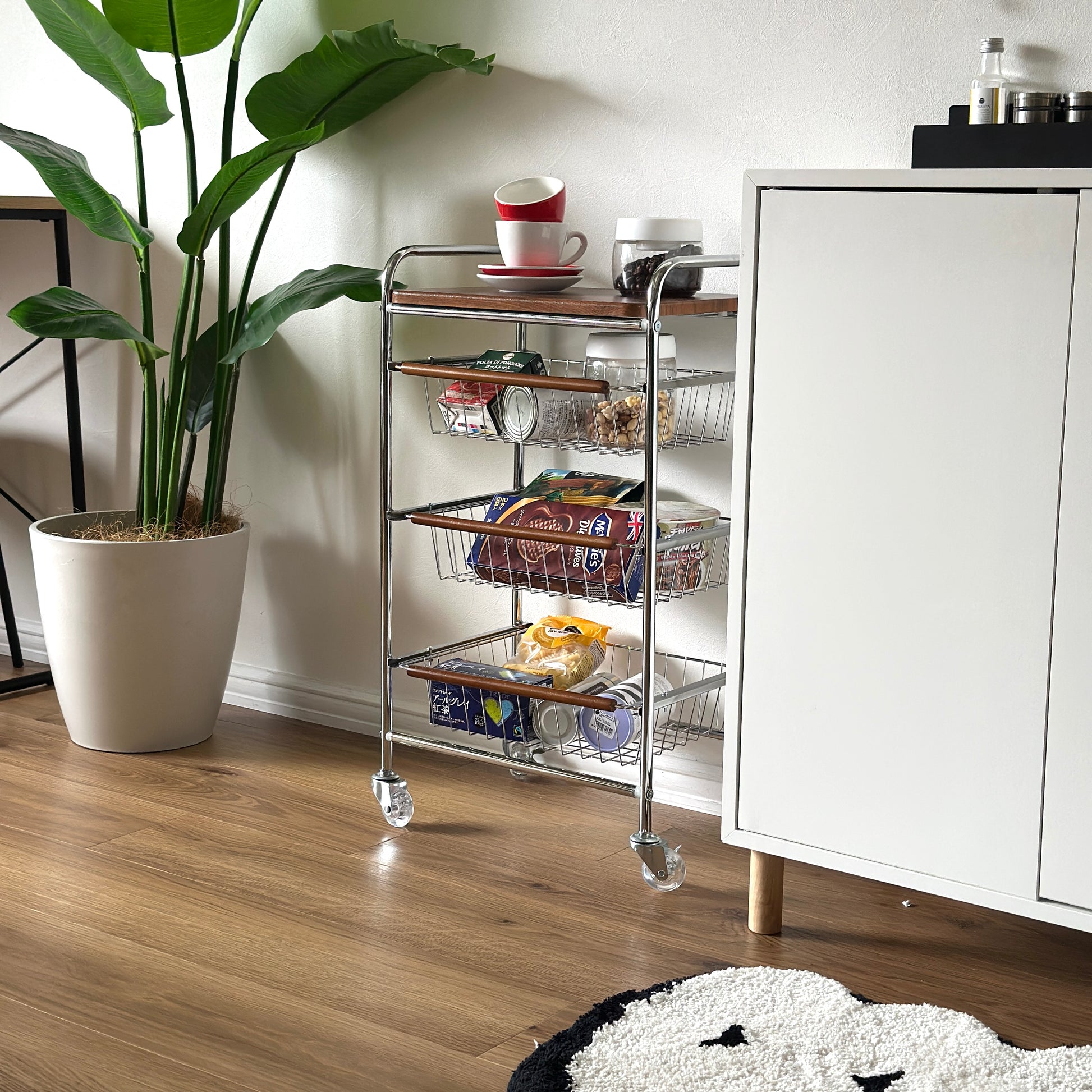 ステンレスとウッド天板の収納ワゴンに食料品を収納している様子