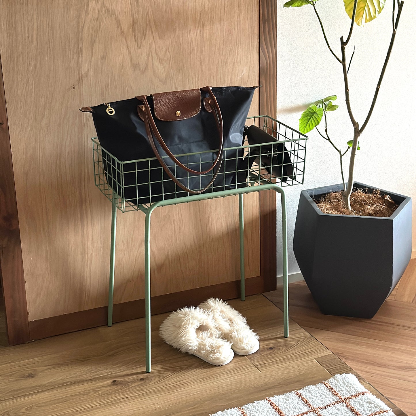 エネラルドのアイアン素材とワイヤーメッシュデザインの収納ワゴンを玄関に置いている様子
