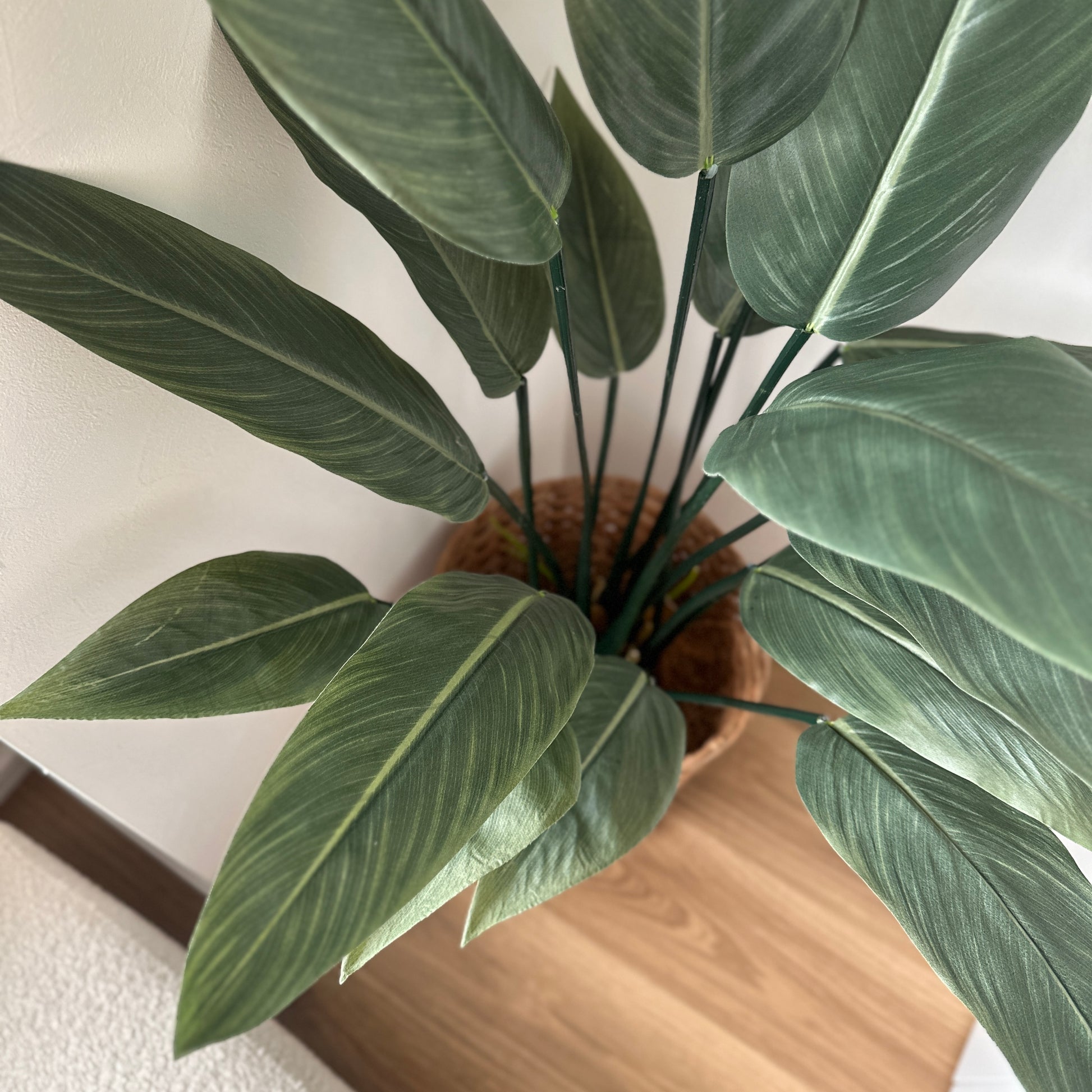 フェイクグリーンのストレリチアで、編みバスケットに入った緑豊かな人工観葉植物です。