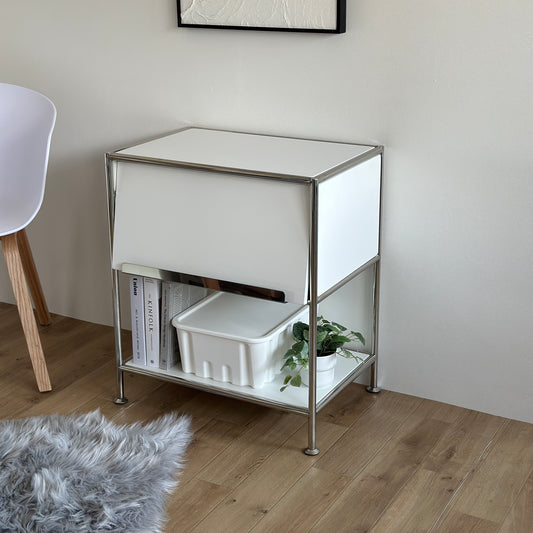 白のモジュール棚の下の段に雑誌と収納ボックス、植物が置かれてある