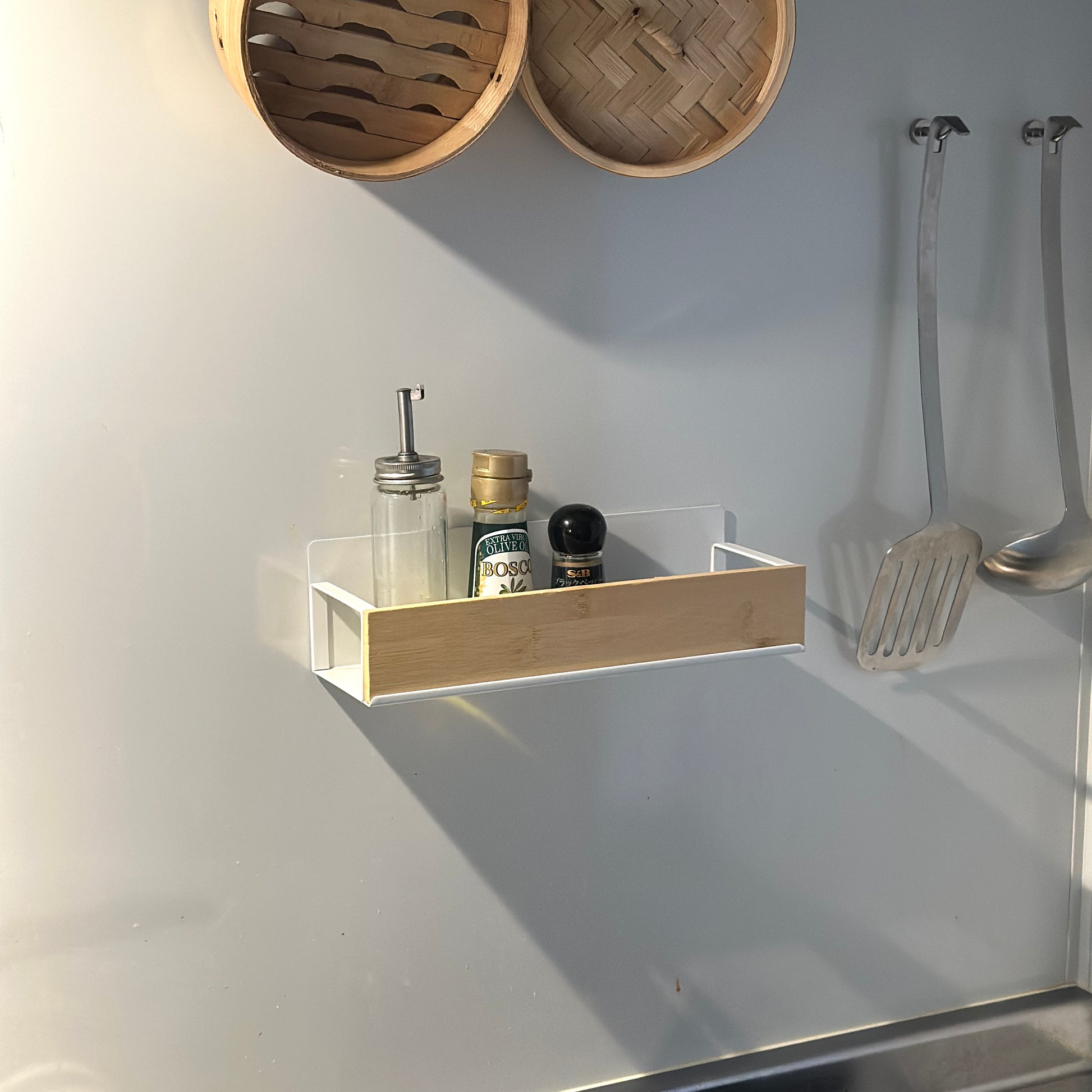 キッチン調味料ラックをキッチンの壁に貼り付けしている様子