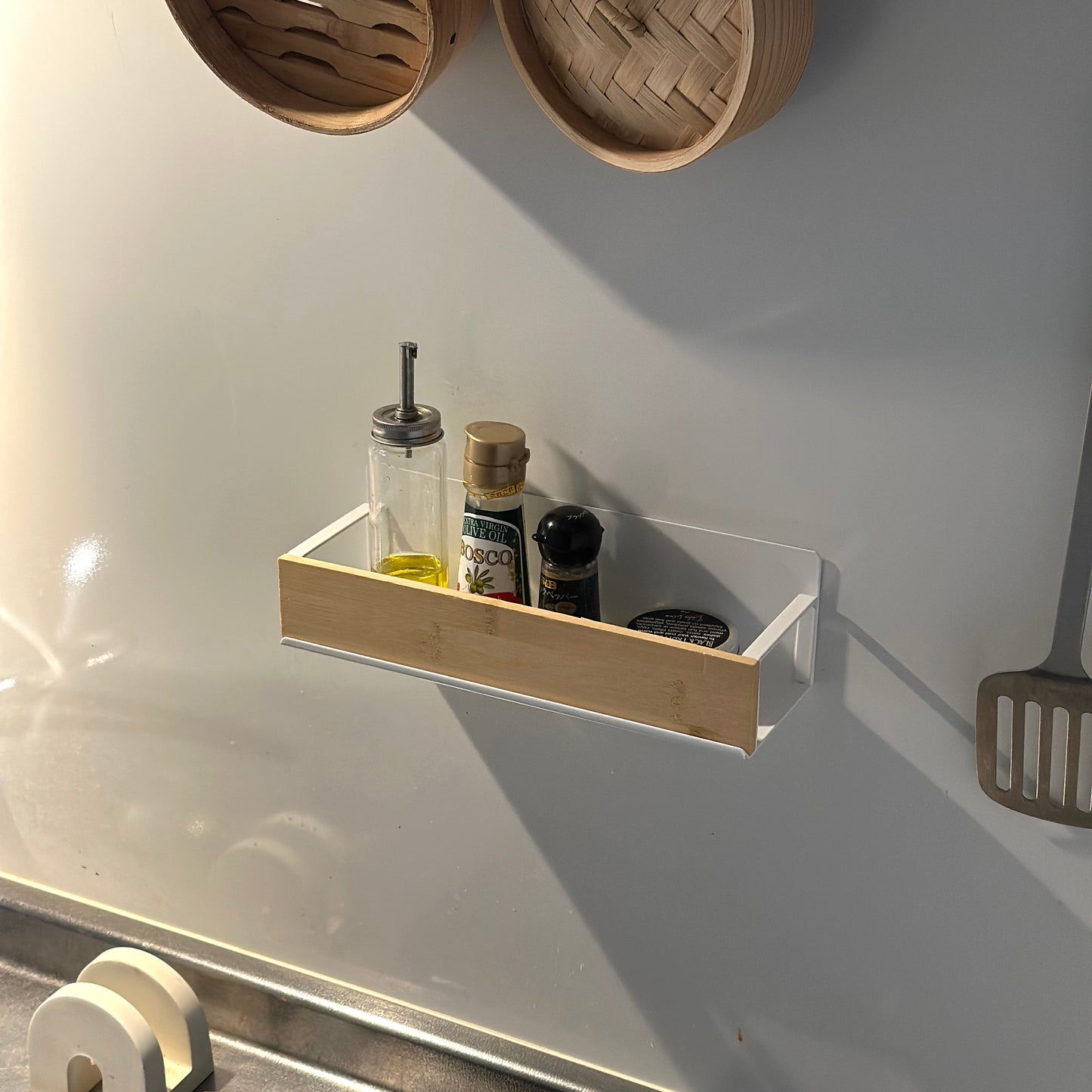 キッチン調味料ラックをキッチンの壁に貼り付けしている様子