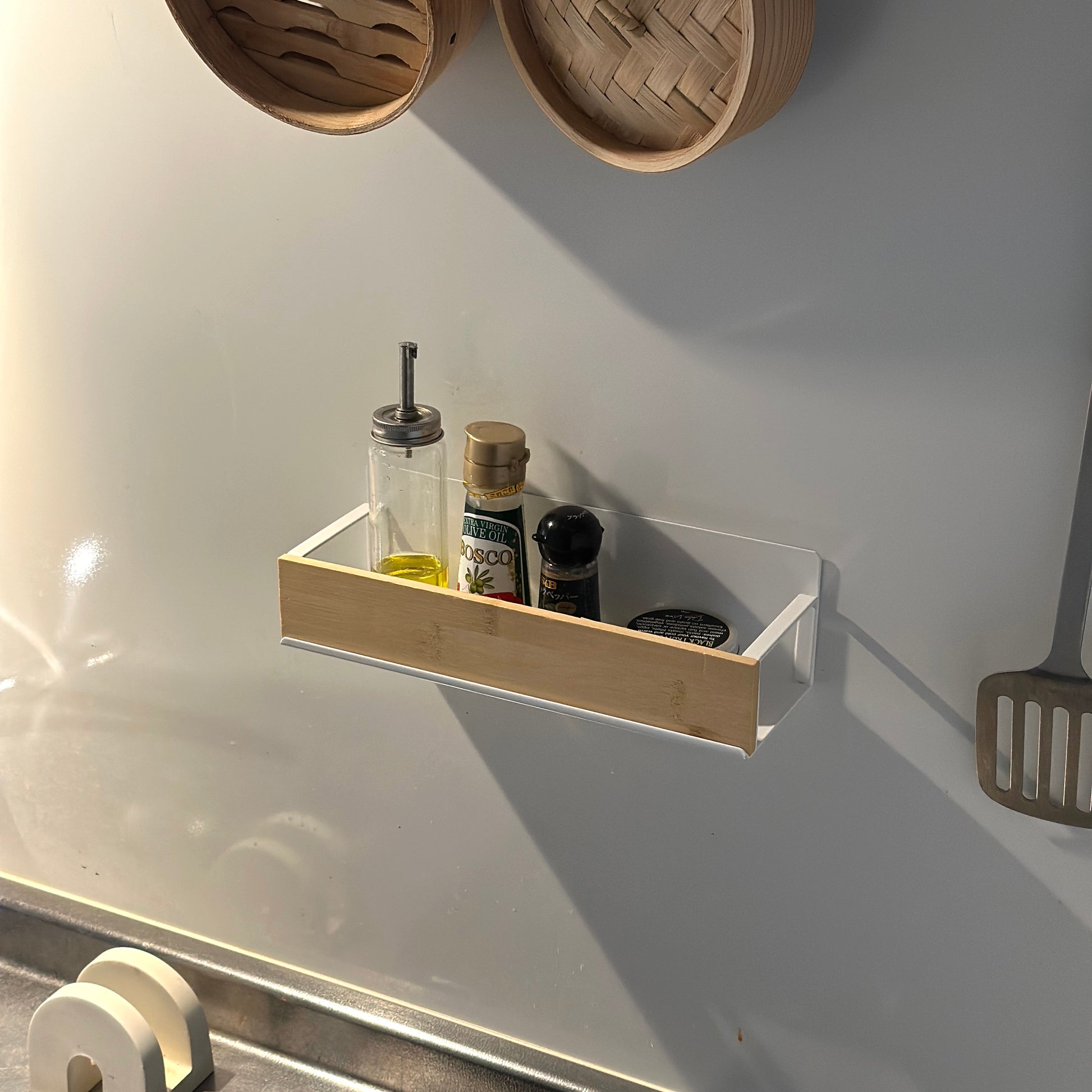 キッチン調味料ラックをキッチンの壁に貼り付けしている様子