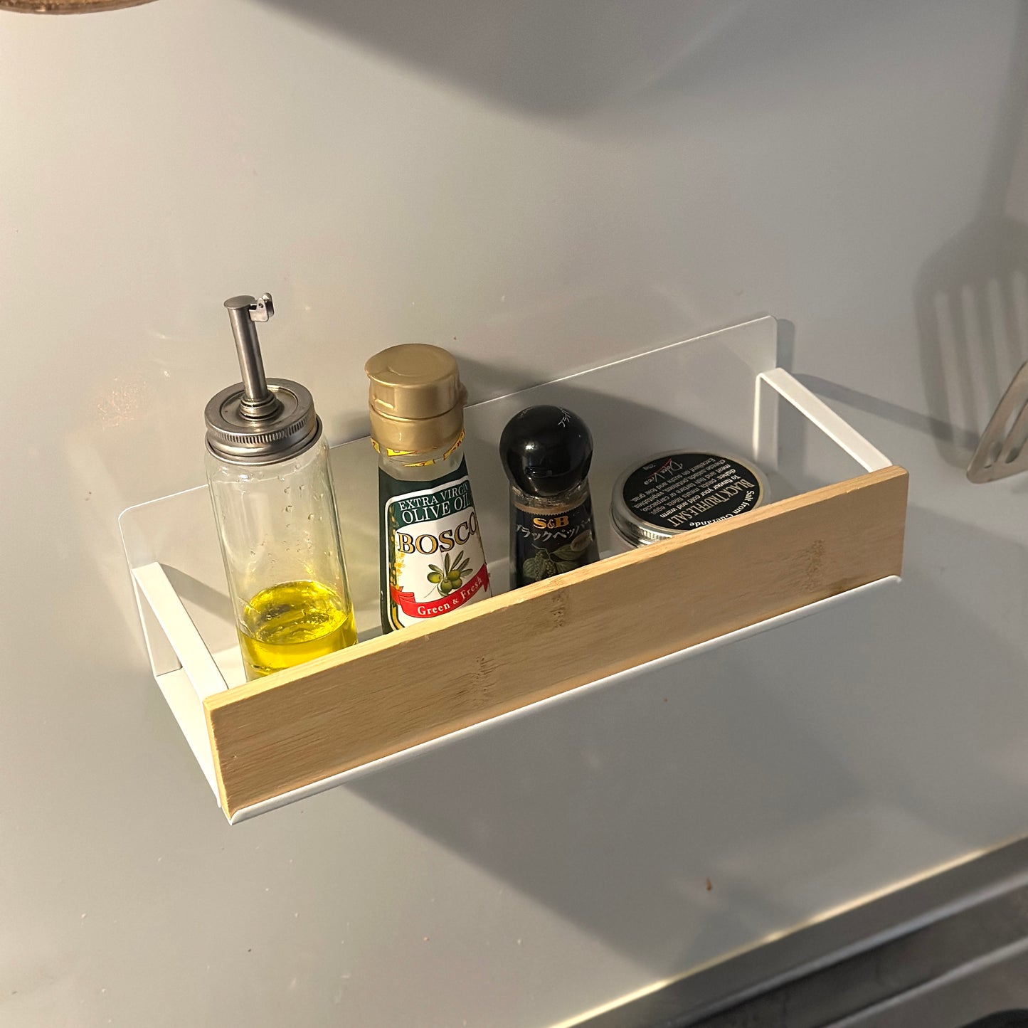 キッチン調味料ラックをキッチン壁に貼り付けしているのをアップで写している様子