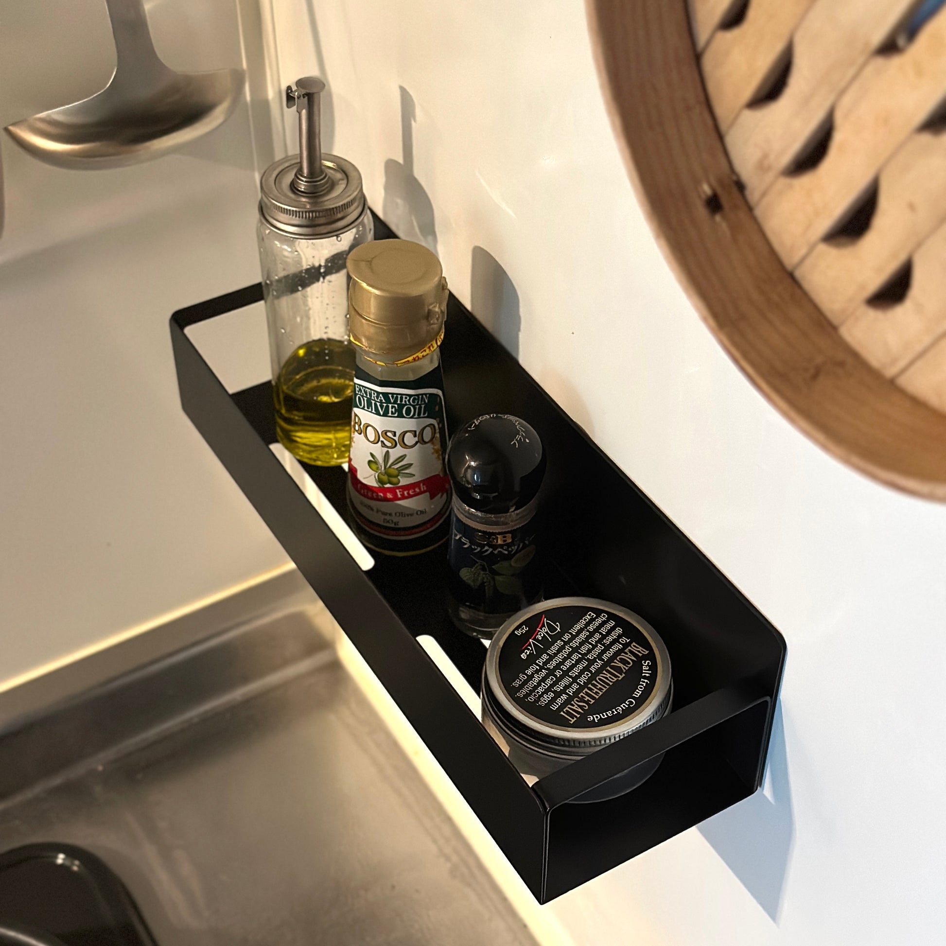 シンプル調味料ラックをキッチンの壁に貼り付けしているのをアップで写している様子