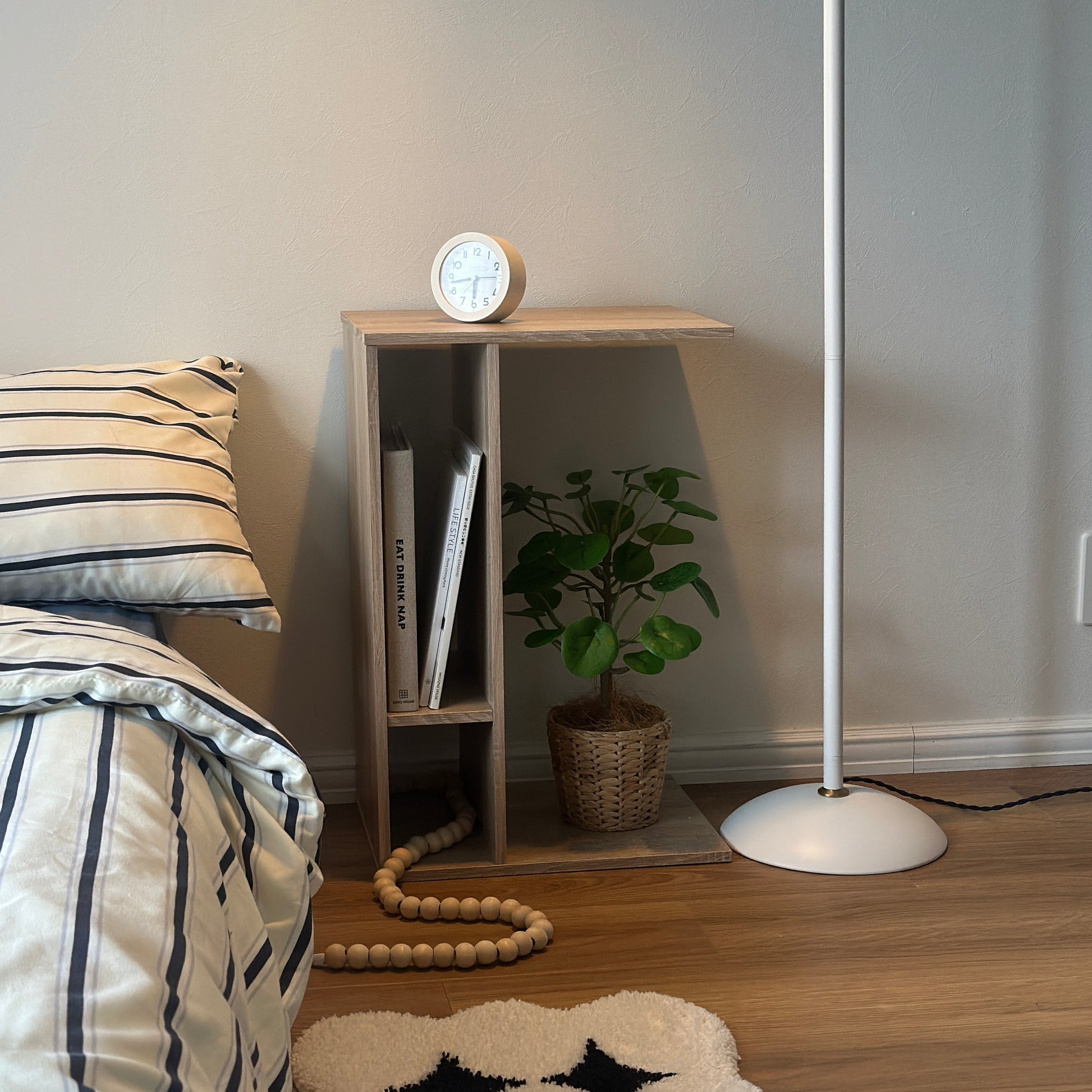 ナチュラルの2way置きサイドテーブルに置き時計や植物、雑誌を置いている様子
