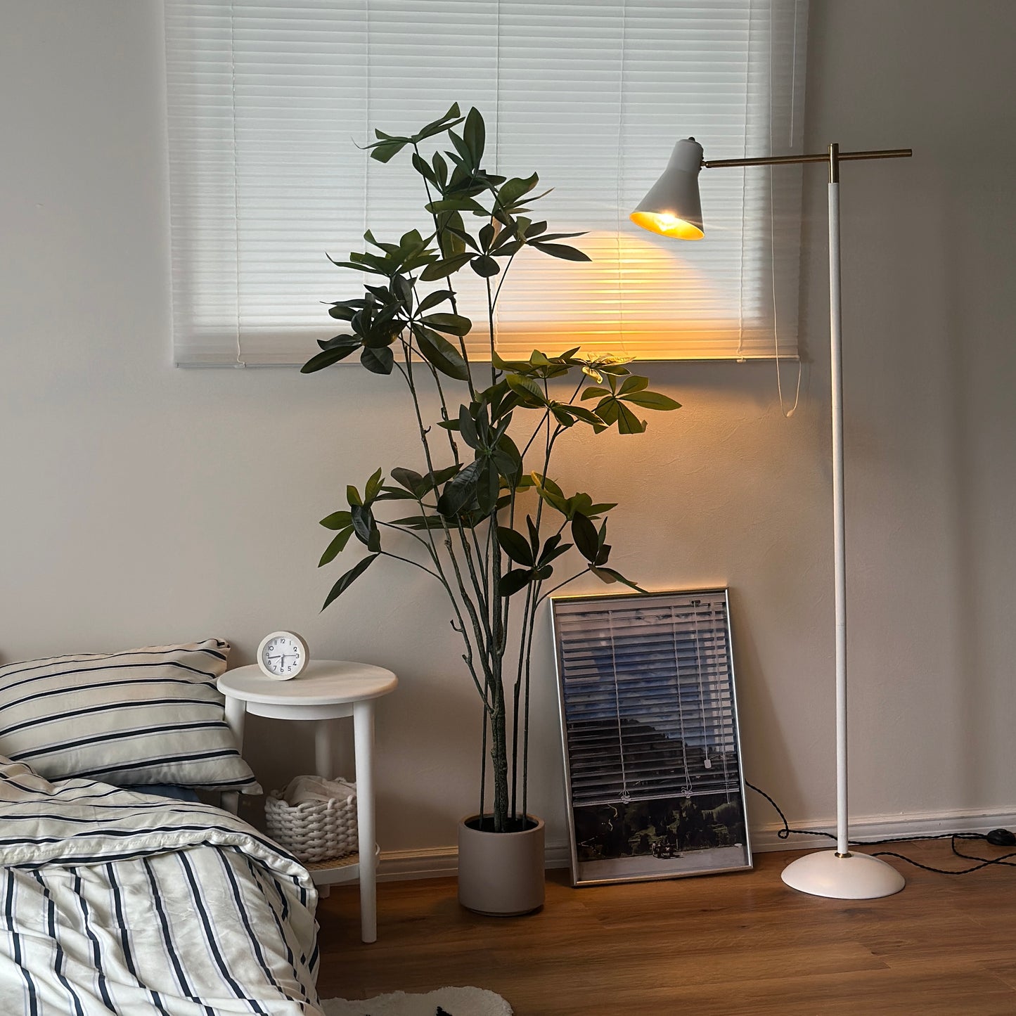 パキラのフェイクグリーンをベッドの横に置いている様子