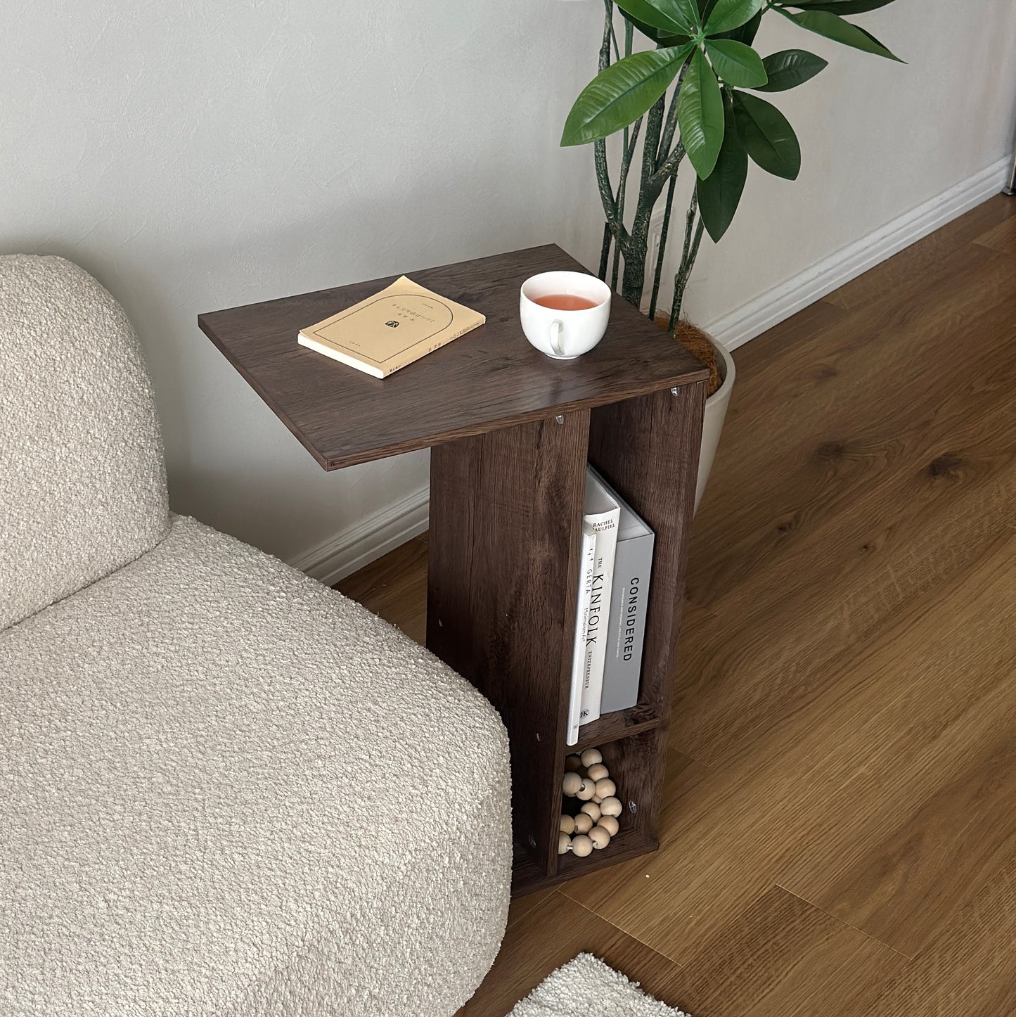 ブラウンの2way置きサイドテーブルに文庫本とコップを置いている様子