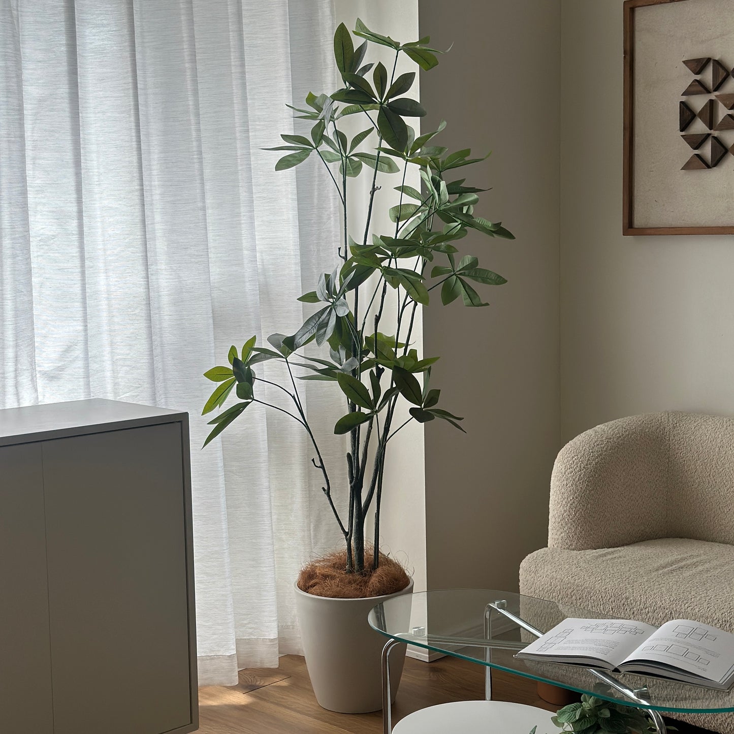 パキラのフェイクグリーンを窓の側に置いている様子