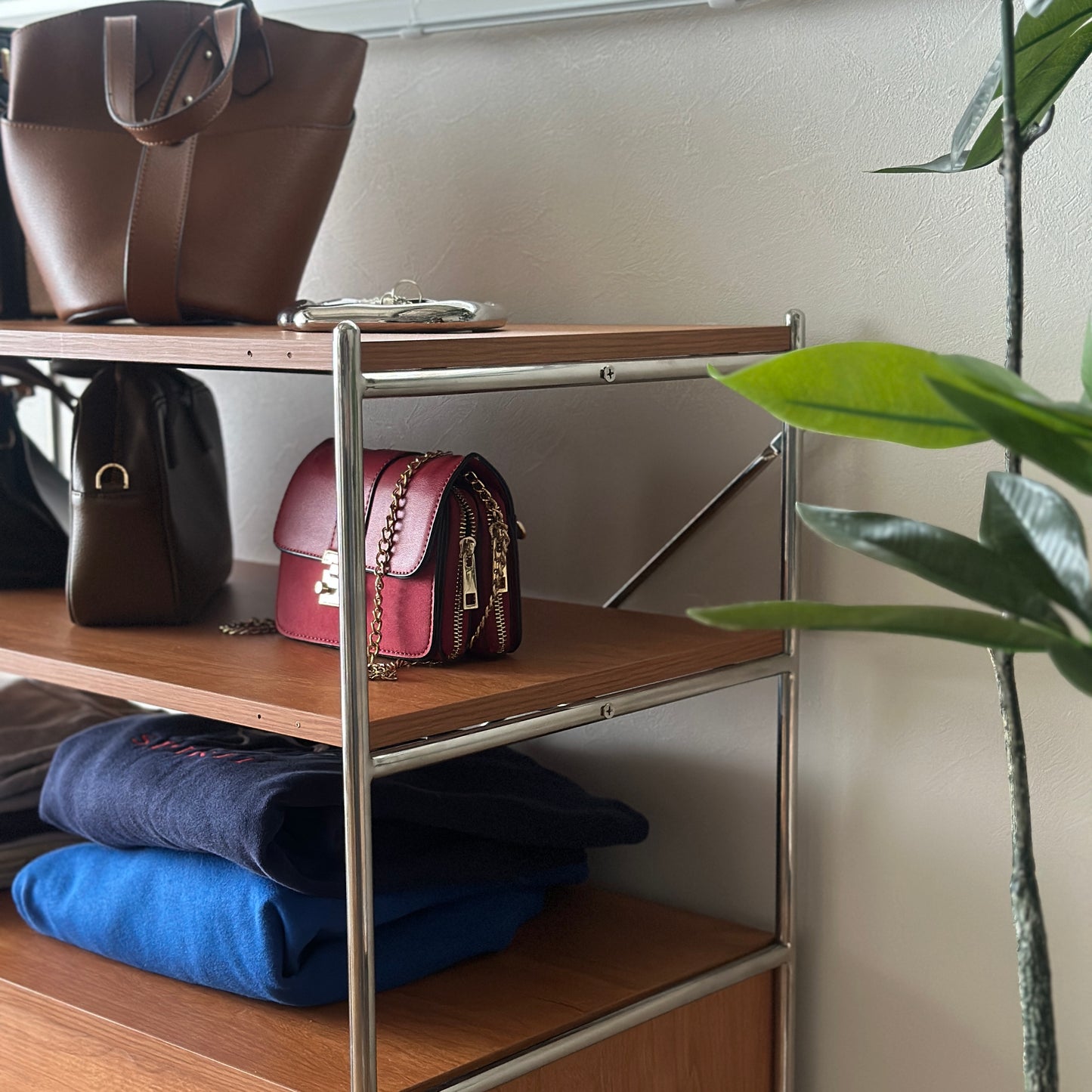 ウッド×アイアン製の引き出しシェルフにバッグや洋服が置かれてある様子