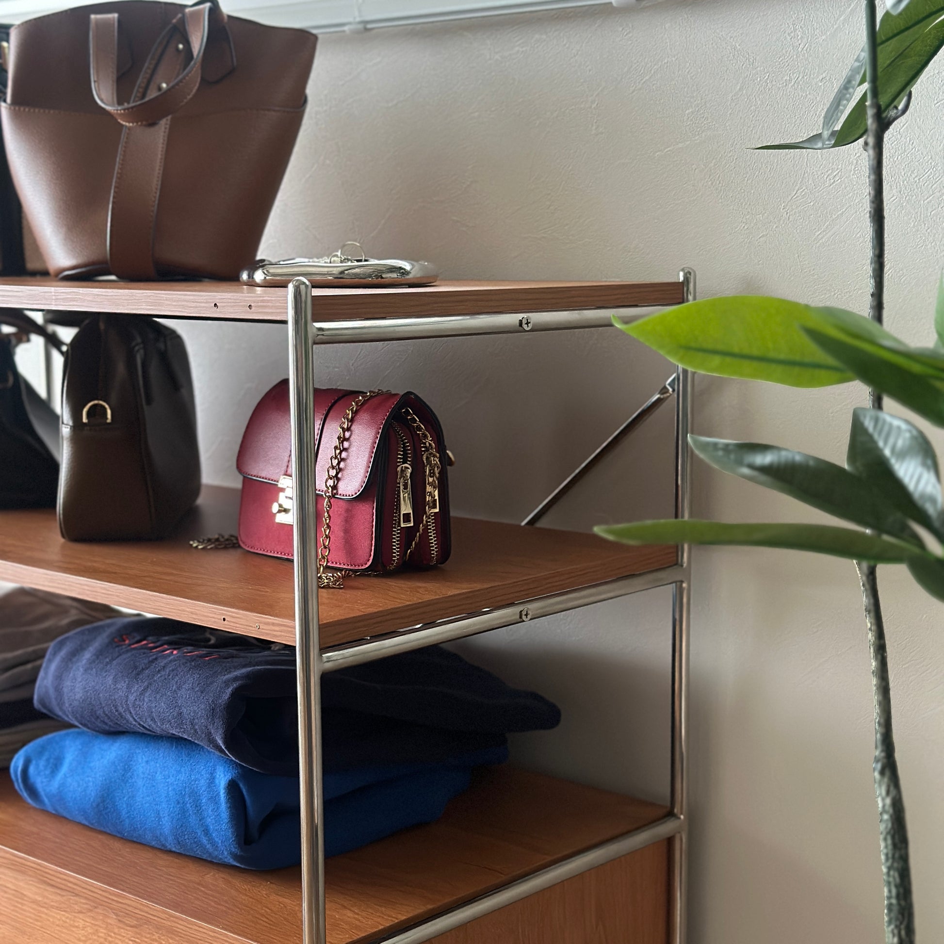ウッド×アイアン製の引き出しシェルフにバッグや洋服が置かれてある様子