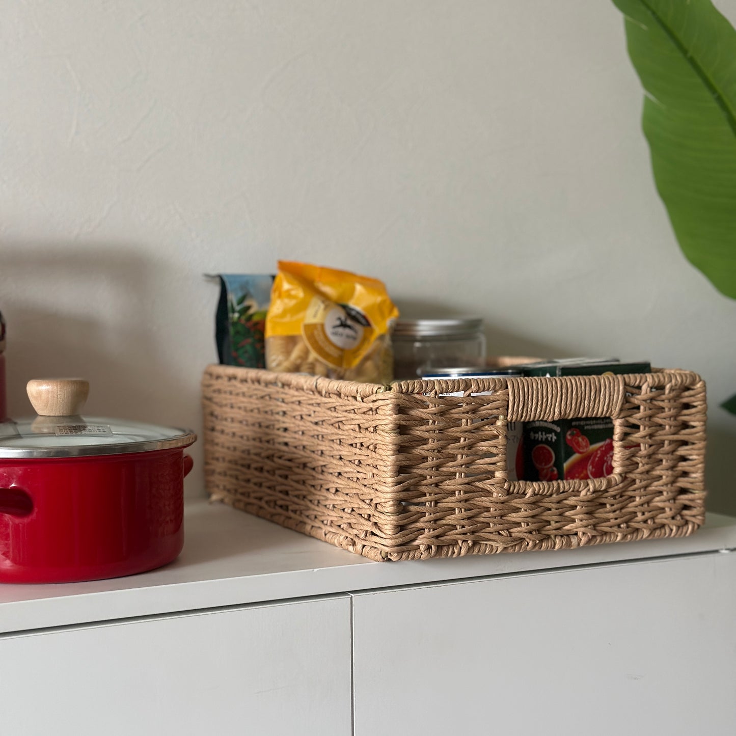 手編みの折り畳み式ペーパーコードバスケットの中に食料品を入れている様子