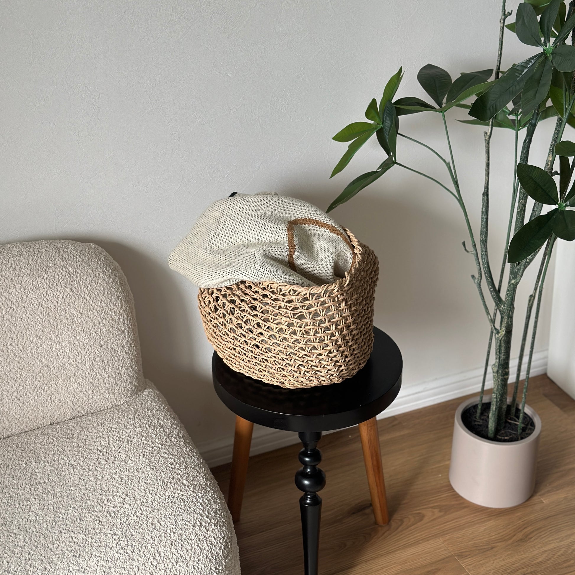 ラウンドのペーパーコードバスケットの中にブランケットを入れている様子