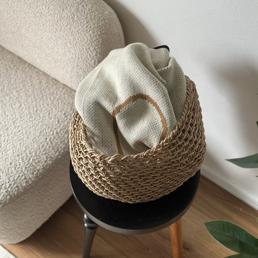 ラウンドのペーパーコードバスケットの中にブランケットを入れている様子