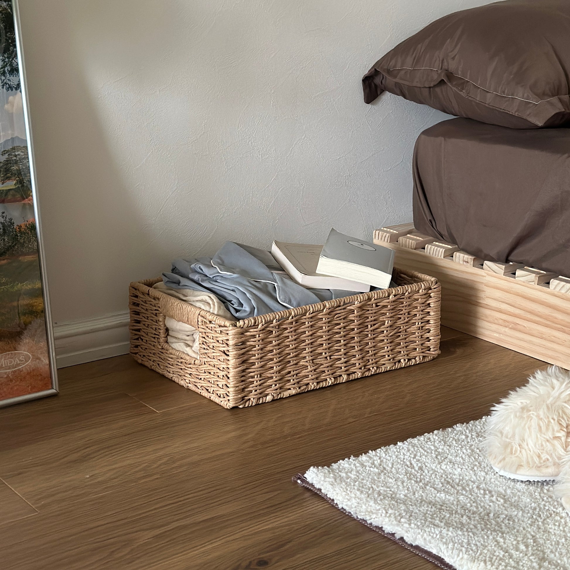 手編みの折り畳み式ペーパーコードバスケットの中にパジャマや文庫本が入っている様子