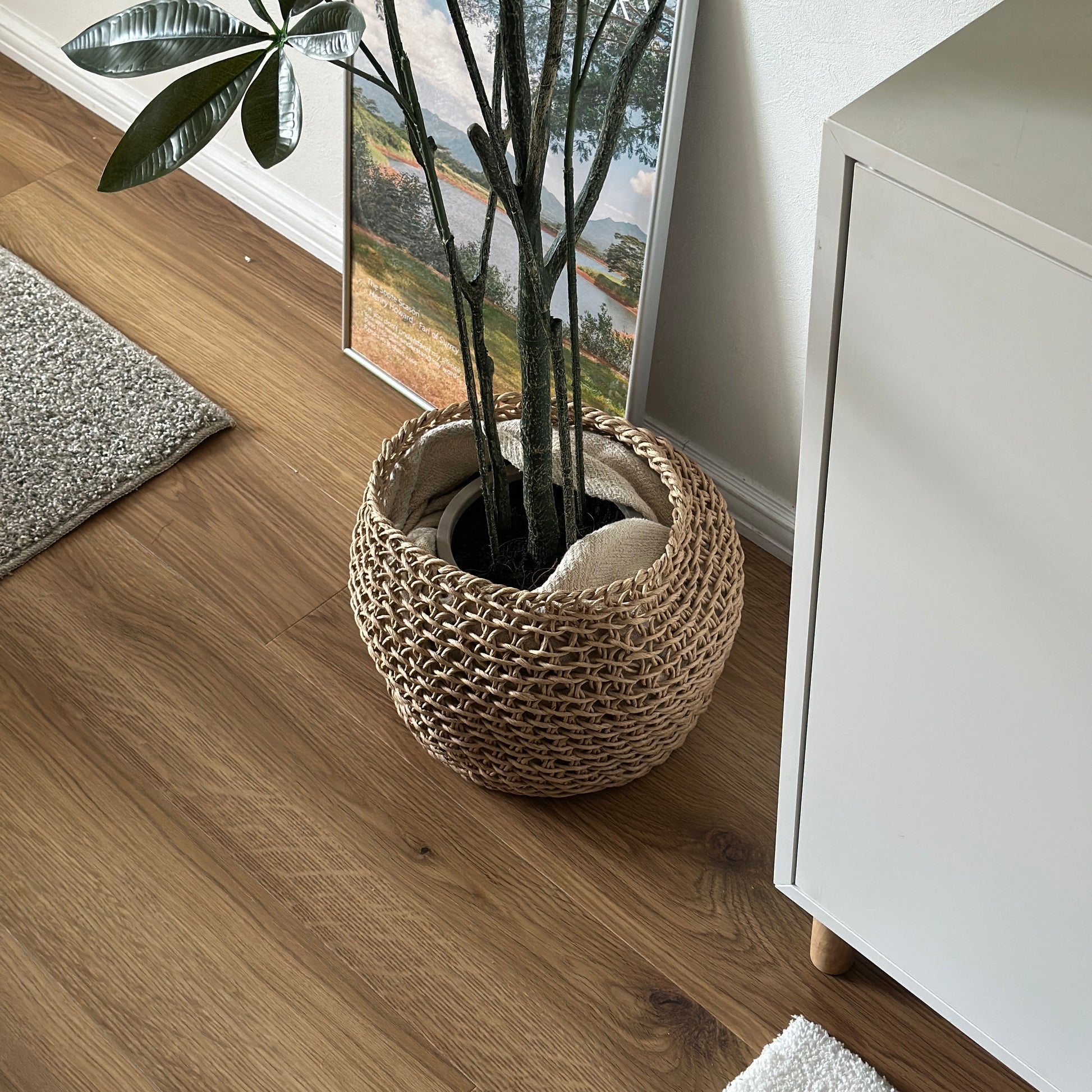 ラウンドのペーパーコードバスケットに観葉植物の植木鉢部分を入れている様子