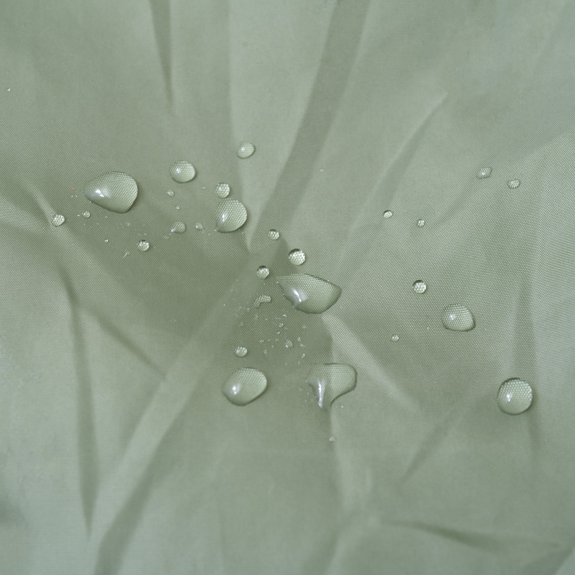 ライトグリーンのキルティング素材のこたつ布団が水を弾いている様子