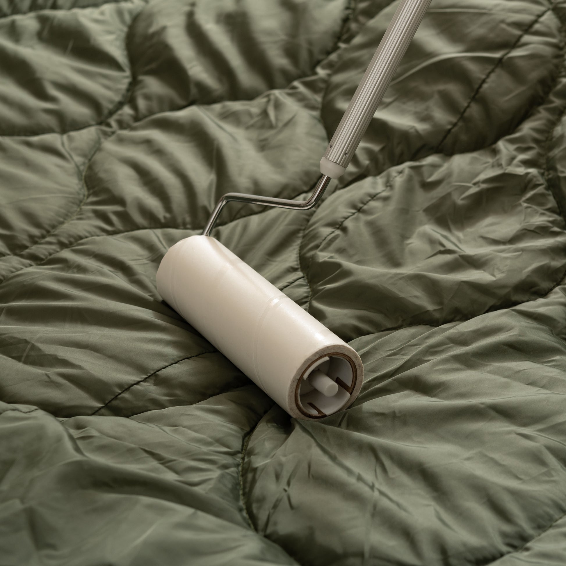 ライトグリーンのキルティング素材のこたつ布団を掃除している様子